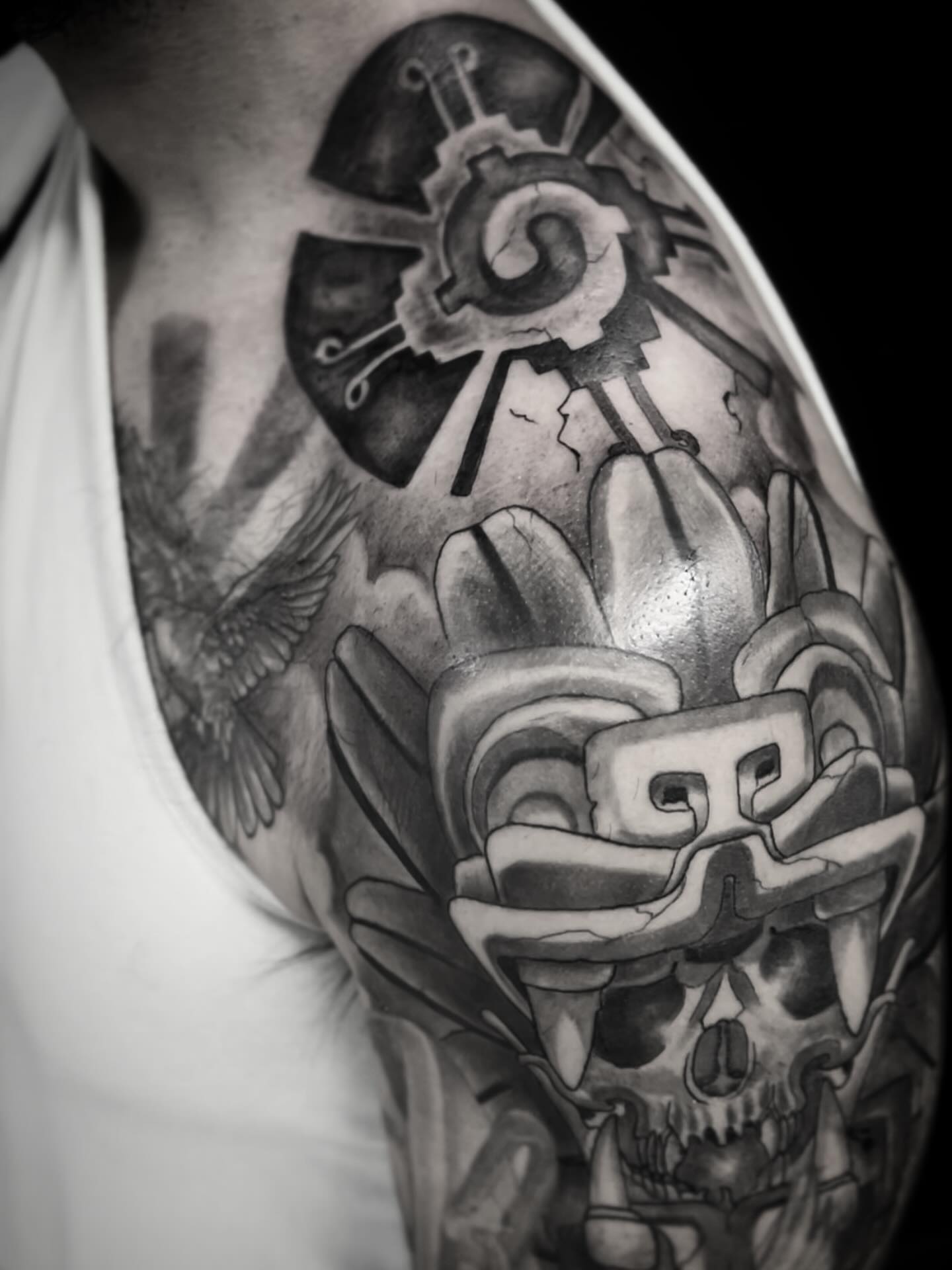 Skull and mask geometric tattoo on the shoulder by H.G