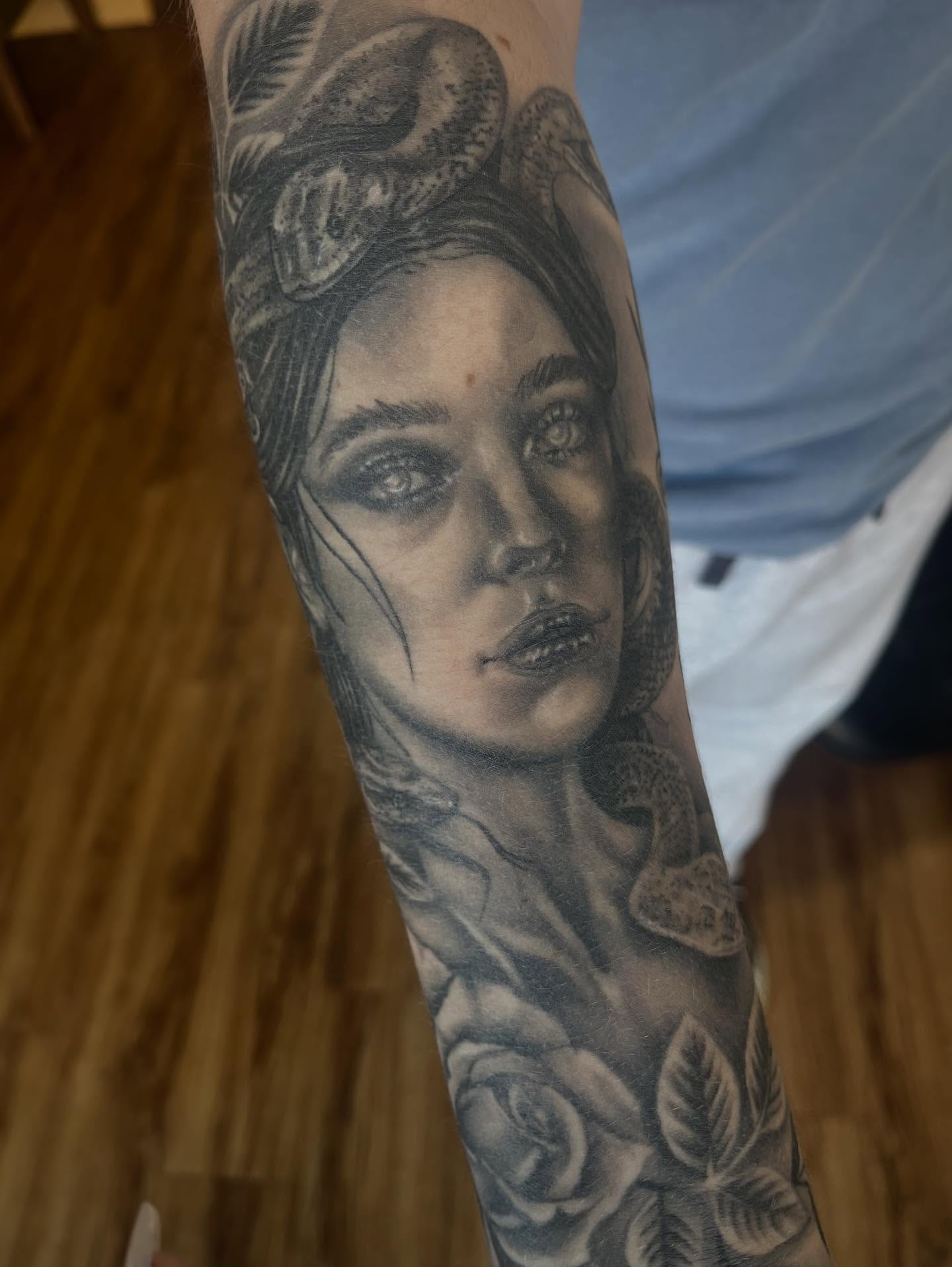 Woman with snake realism tattoo on the forearm by Taylor Santavicca