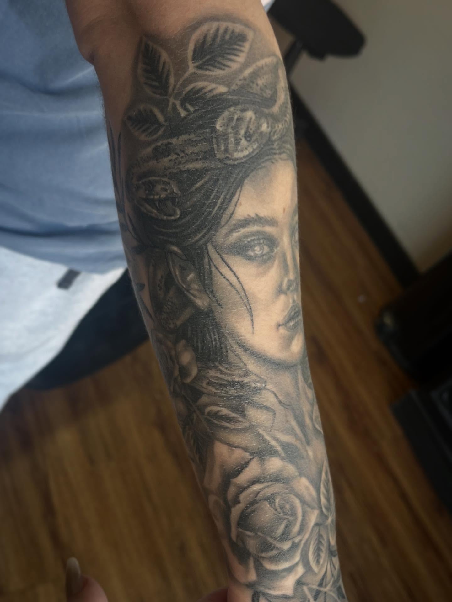 Woman with roses realism tattoo on the forearm by Taylor Santavicca