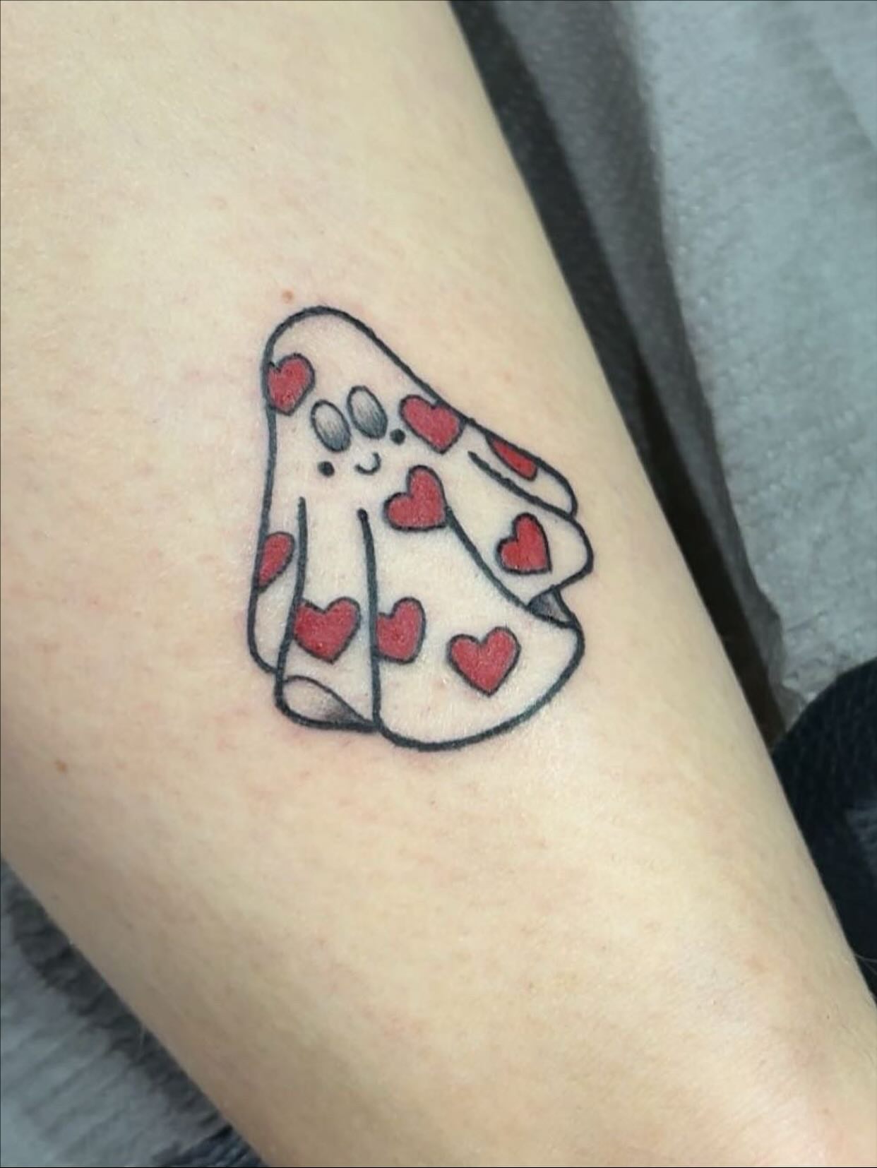 Ghost with hearts dotwork tattoo on the forearm by Molly Dixon