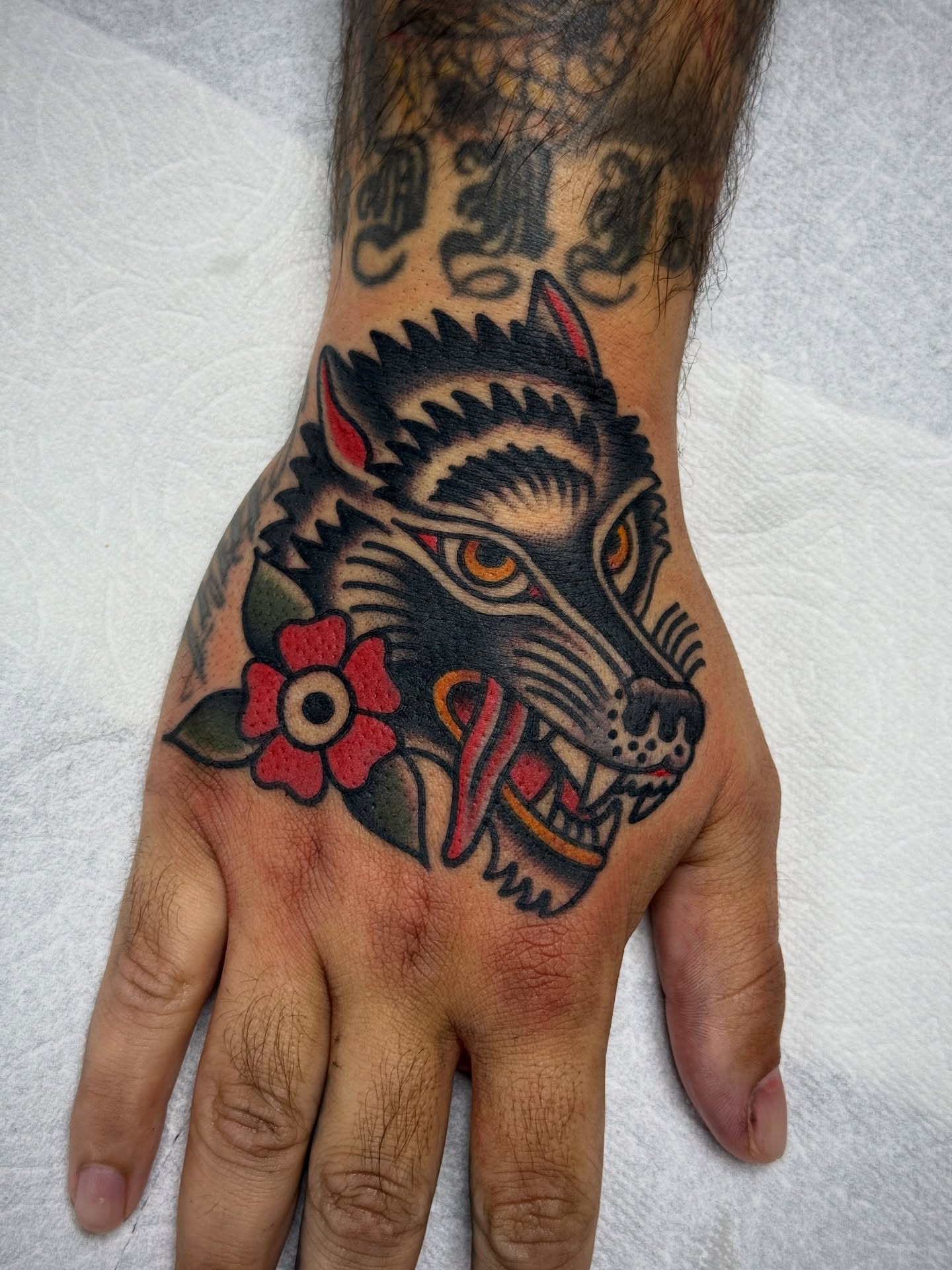 Wolf head American traditional tattoo on the hand by Jordan Allen
