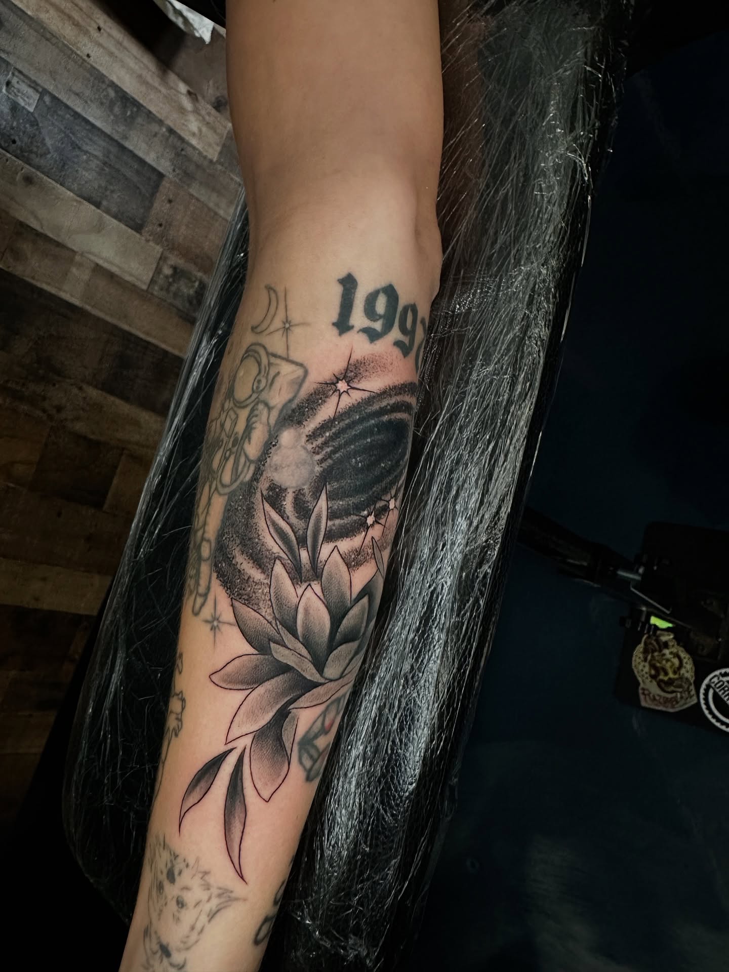 Lotus flower black and grey tattoo on the forearm by Sam Minneci