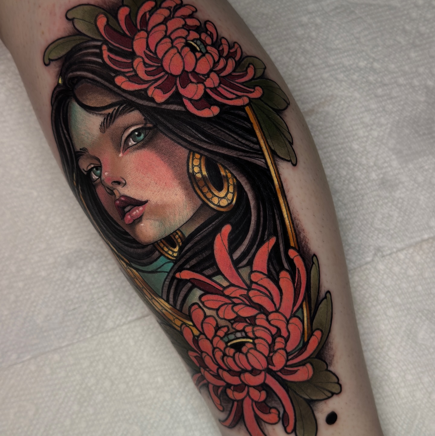 Woman with flowers realism tattoo on the forearm by Golden Heart Tattoo Co