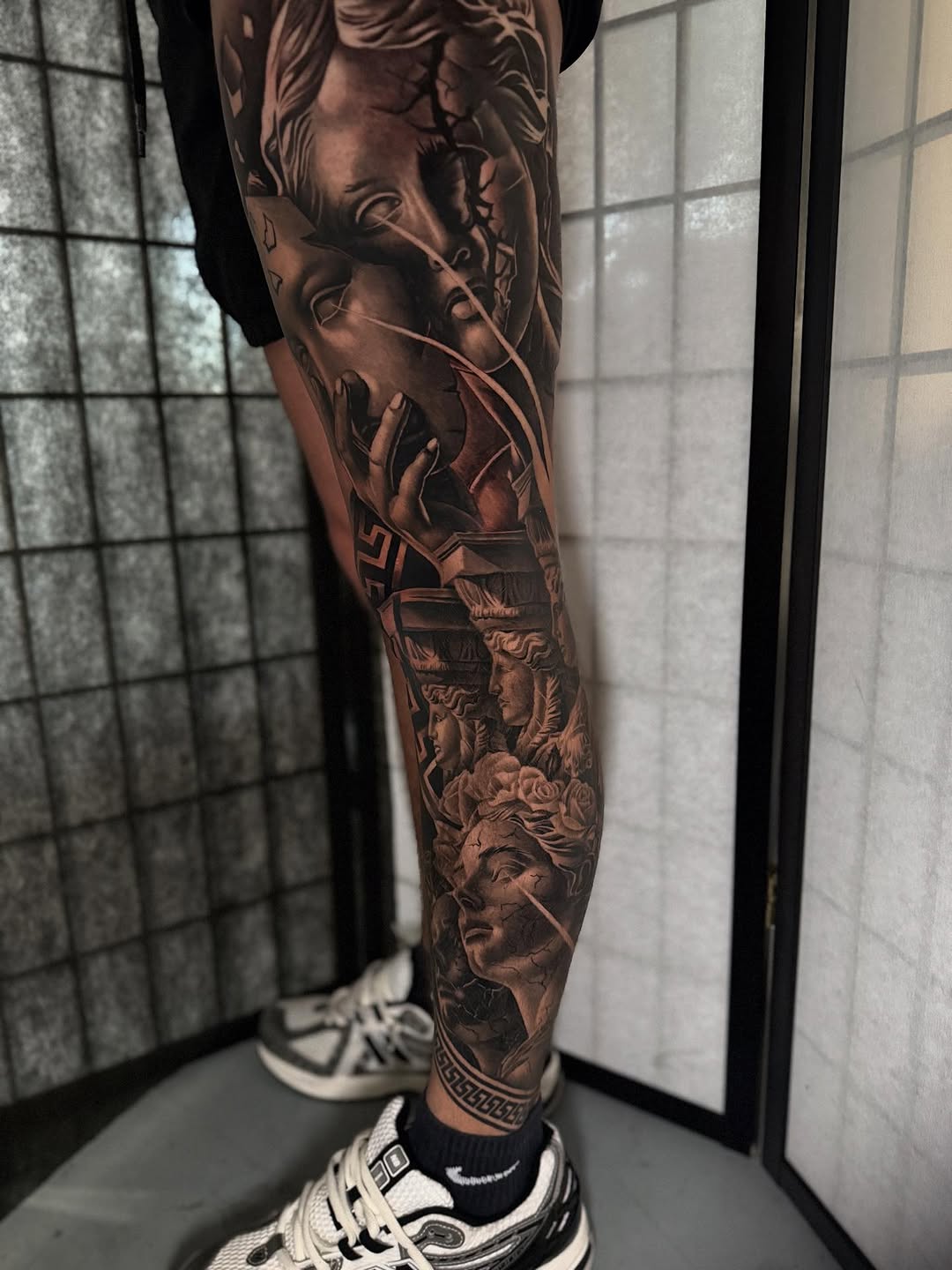 Classical statues and roses surrealism tattoo on the forearm by Miles Johnson
