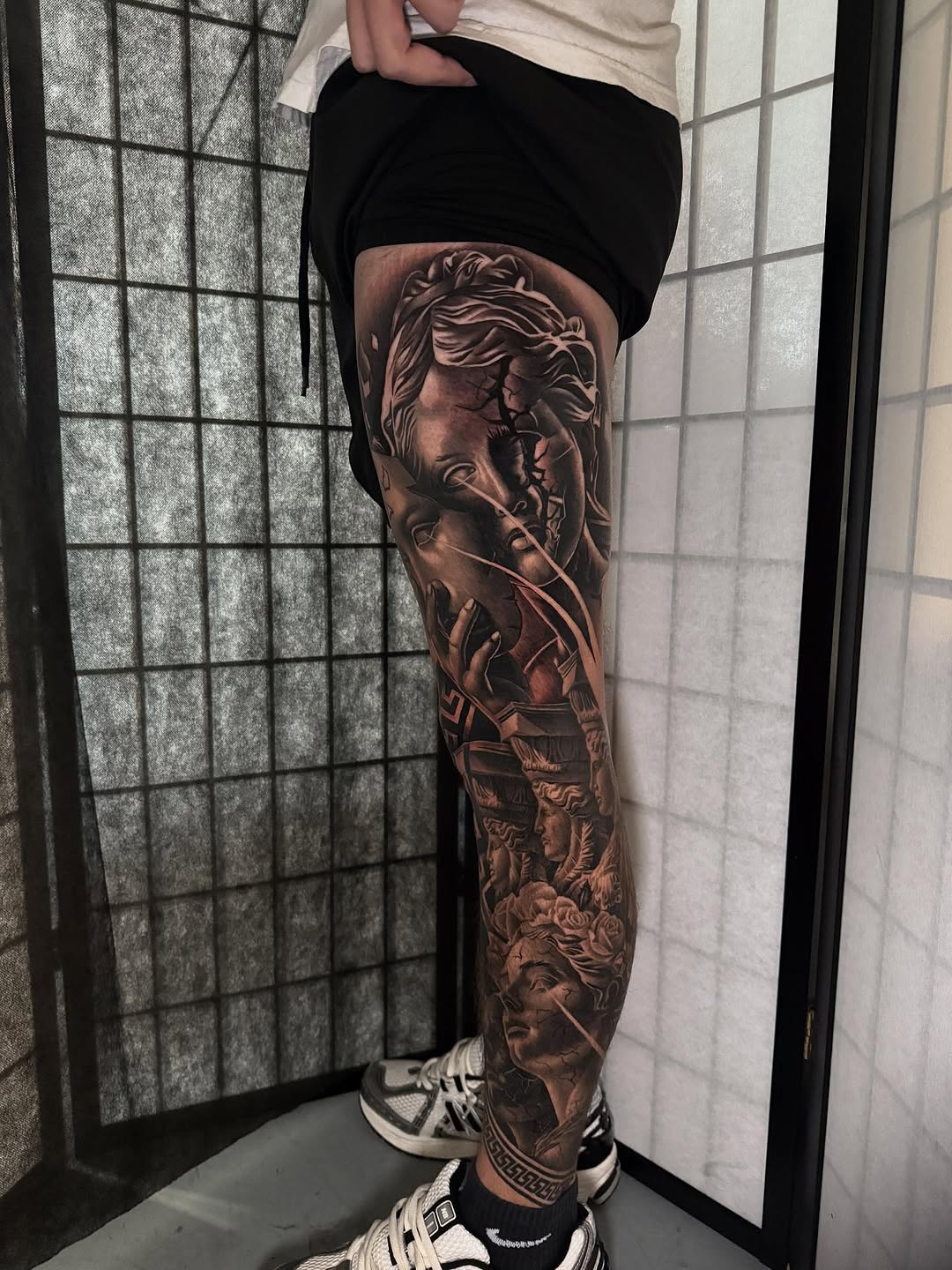Classical statues and architectural elements surrealism tattoo on the leg by Miles Johnson