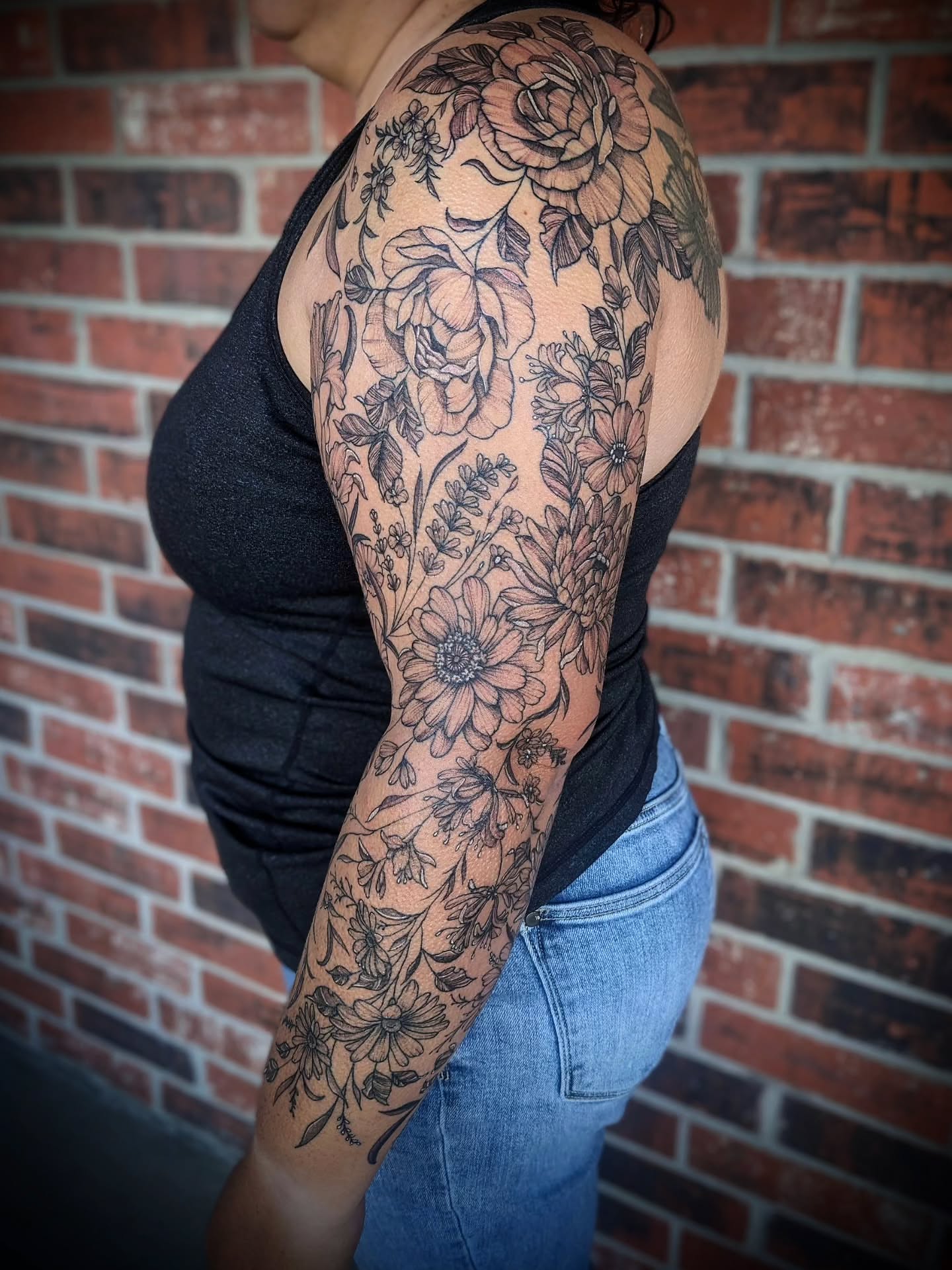 Floral bouquet black and grey tattoo on the upper arm by 𝕸𝖆𝖉𝖎 (𝕸𝖆𝖉 𝕯𝖔𝖌)