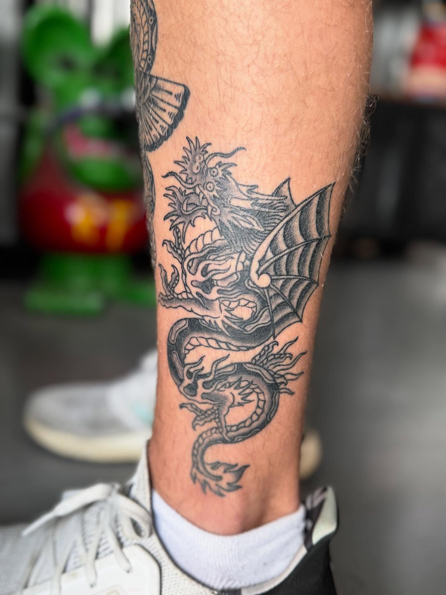 Dragon black and grey tattoo on the calf by Cole Pittman Memphis Tattoo artist, Memphis, Tennessee