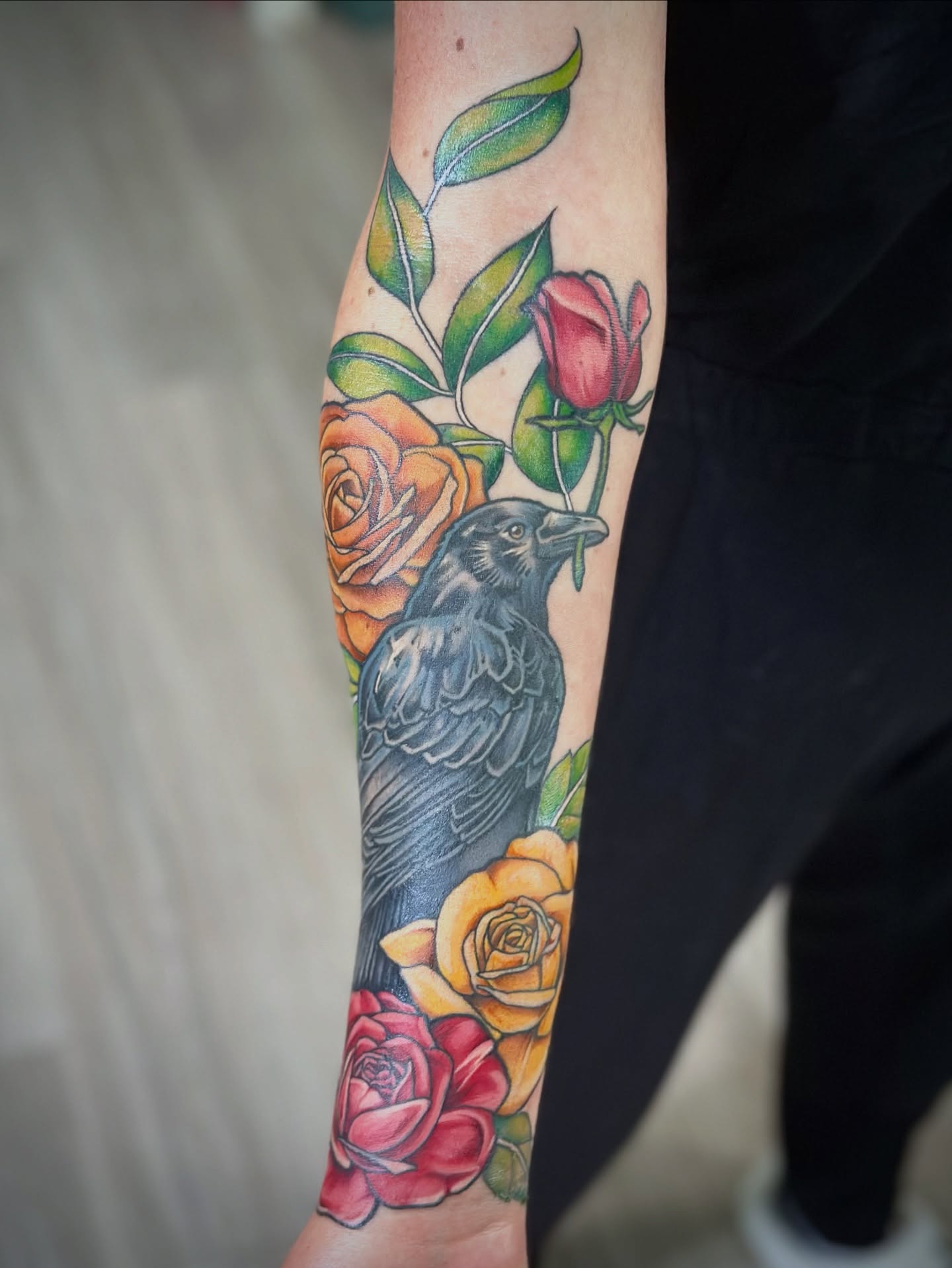 Crow and roses realism tattoo on the forearm by Maddie Morrill