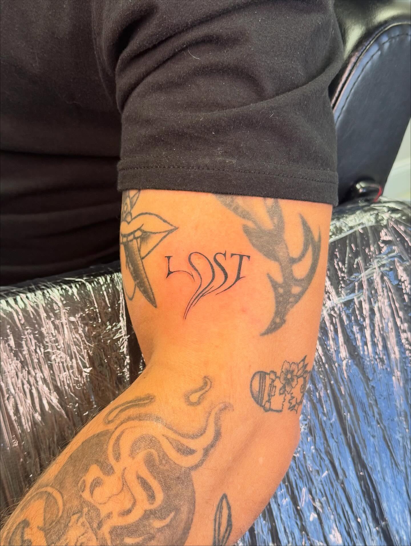 Antlers and script black and grey tattoo on the forearm by haylie