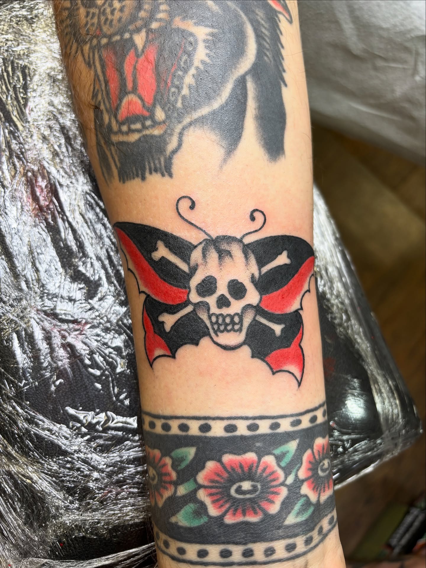 Skull and butterfly American traditional tattoo on the forearm by Mike DiCicco