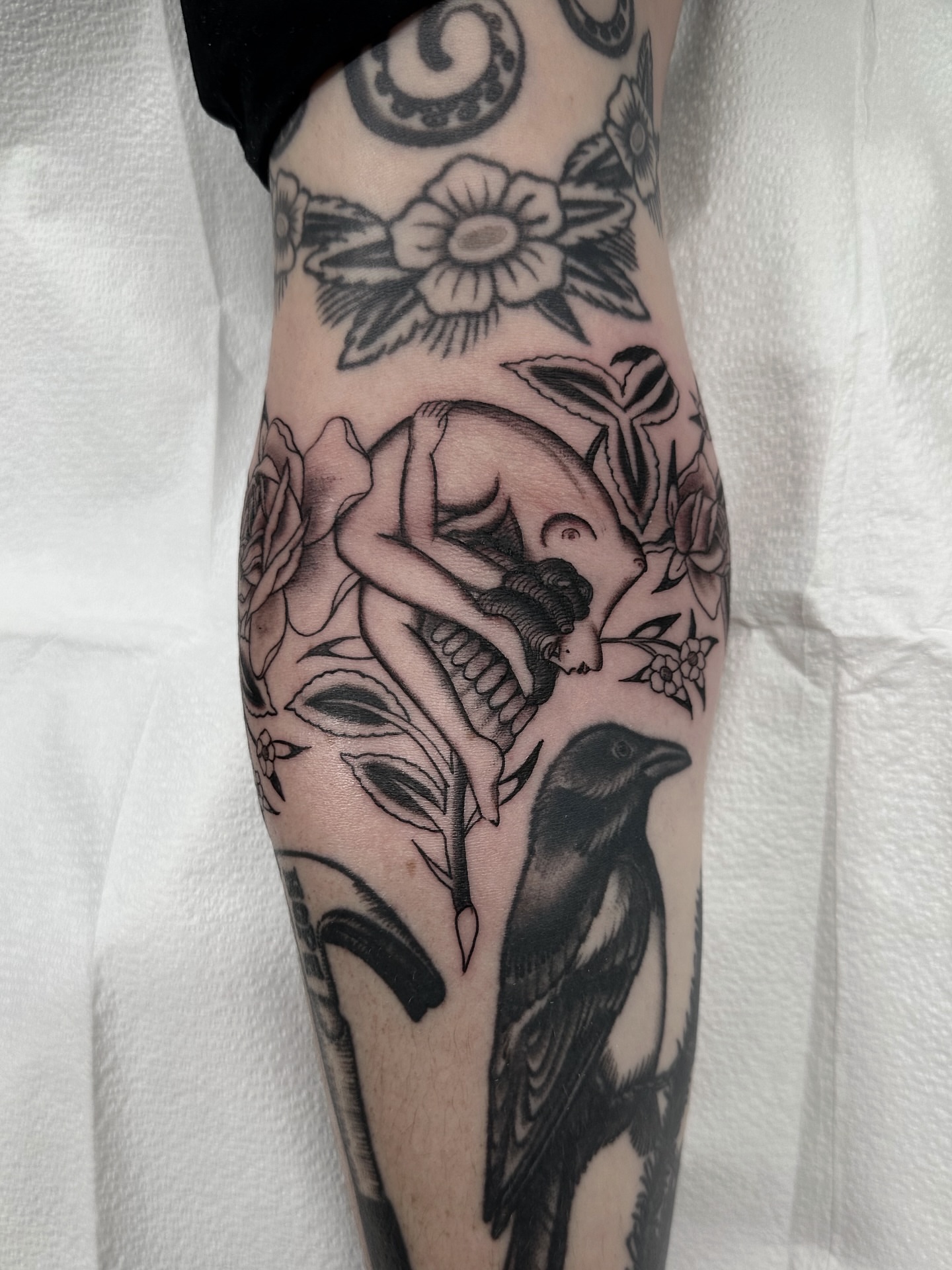 Naked woman with bird American traditional tattoo on the forearm by Nicholas Lee, San Francisco, California
