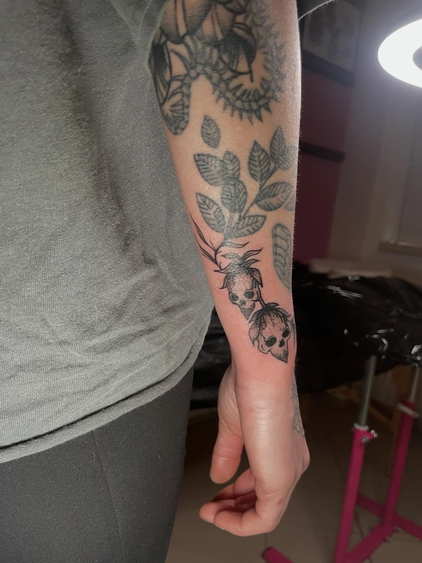 Skulls and leaves black and grey tattoo on the forearm by lu ๐