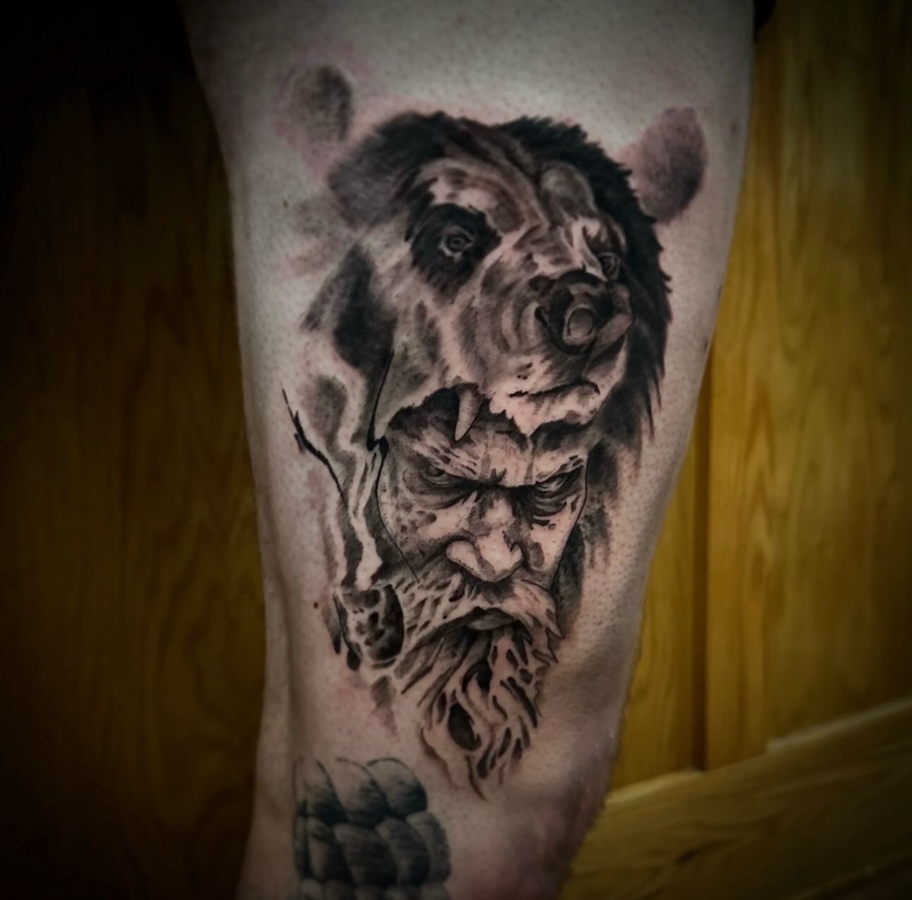 Bear and man realism tattoo on the thigh by Sebastian Livingston