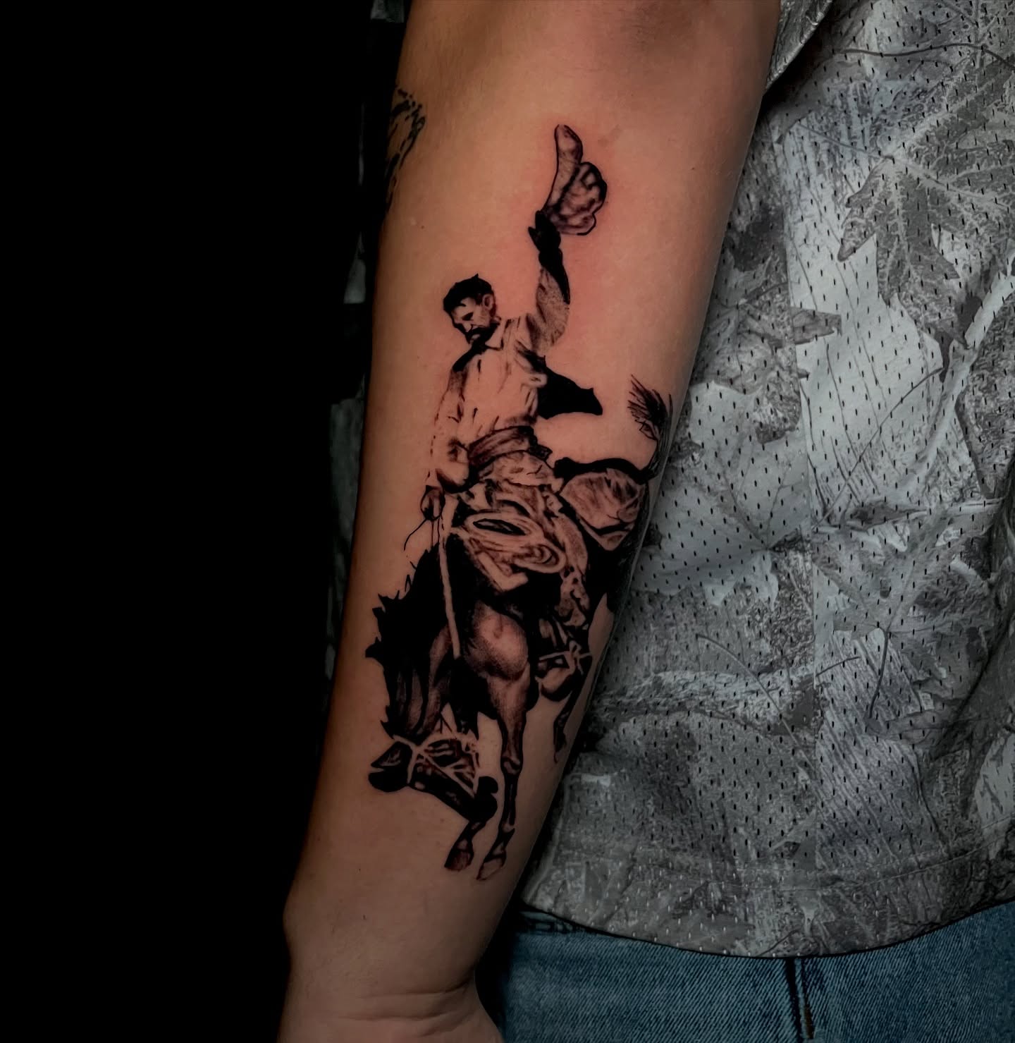 Cowboy riding horse black and grey tattoo on the forearm by Jake, Salt Lake City, Utah