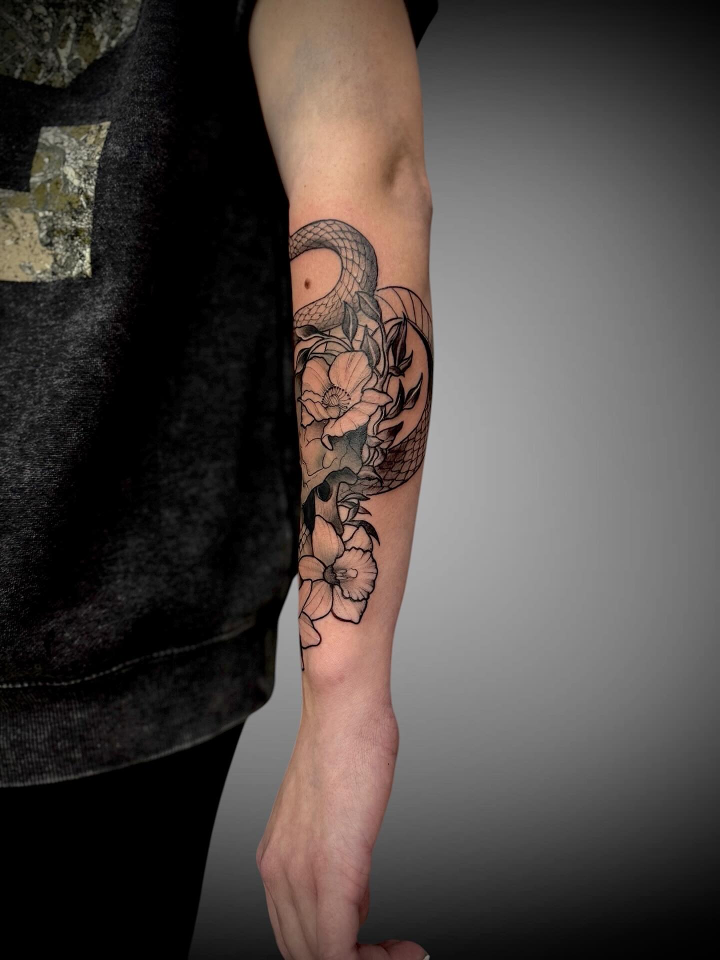 Snake and flowers realism tattoo on the forearm by Mitsuko Ching