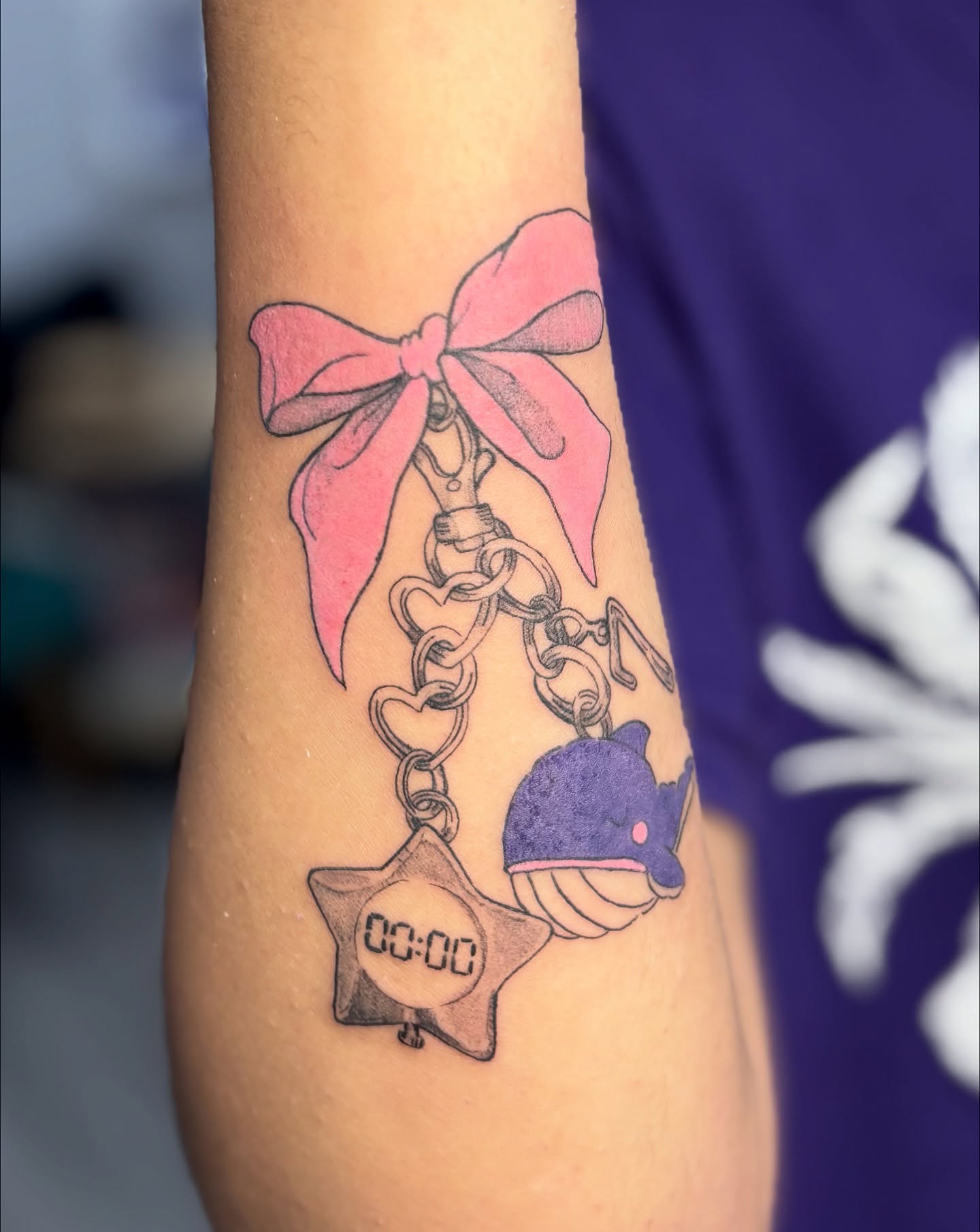 Bow, handcuffs, whale, star dotwork tattoo on the forearm by eli (eh-lee)