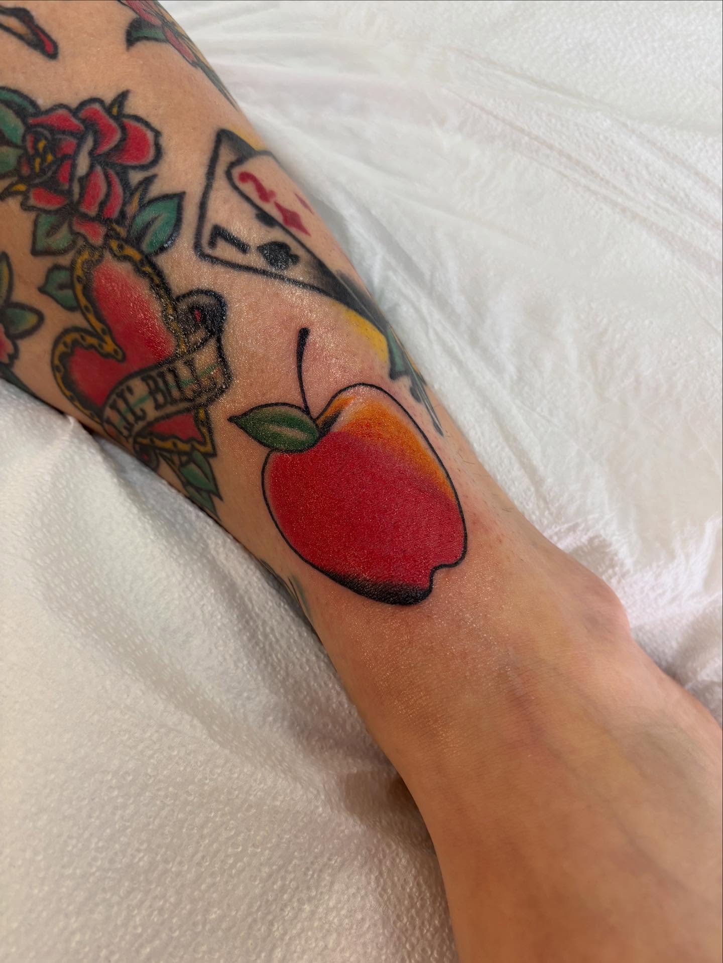 Apple American traditional tattoo on the forearm by Nick Tate