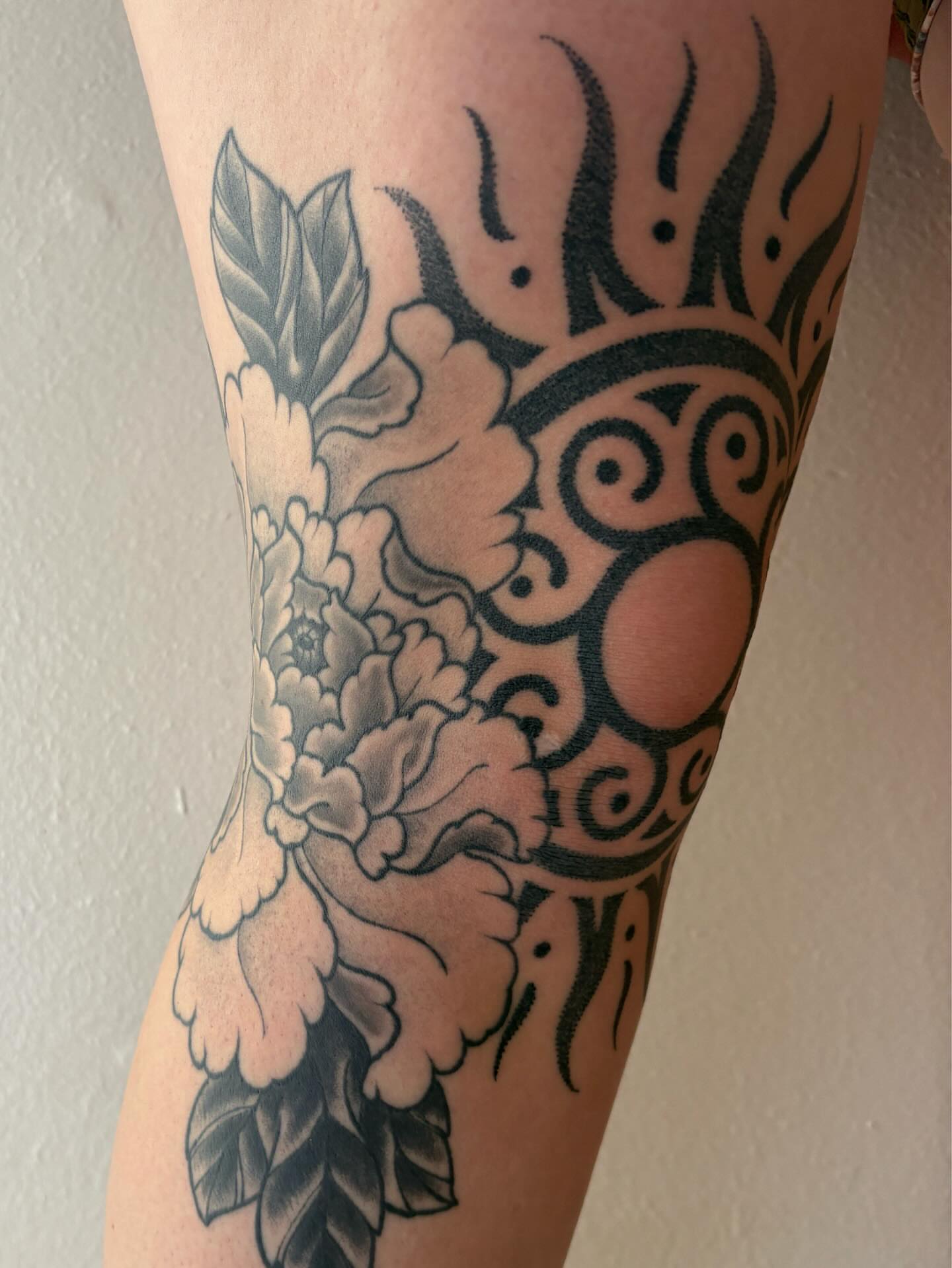 Floral and sun design tribal tattoo on the forearm by Owlyn Madrone
