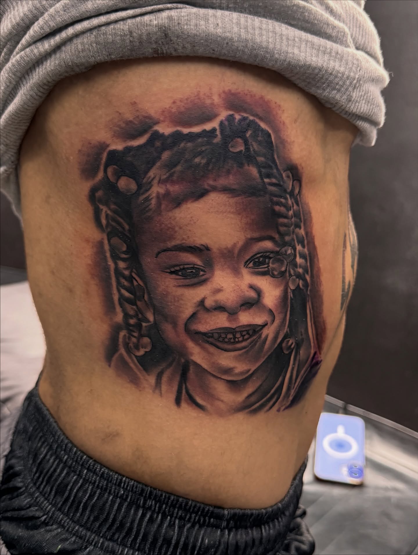 Child's face realism tattoo on the torso by Zeus