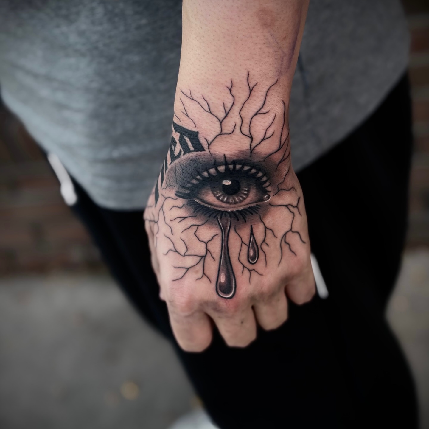 Eye with tears realism tattoo on the hand by Lauren Dempsey, Dearborn, Michigan