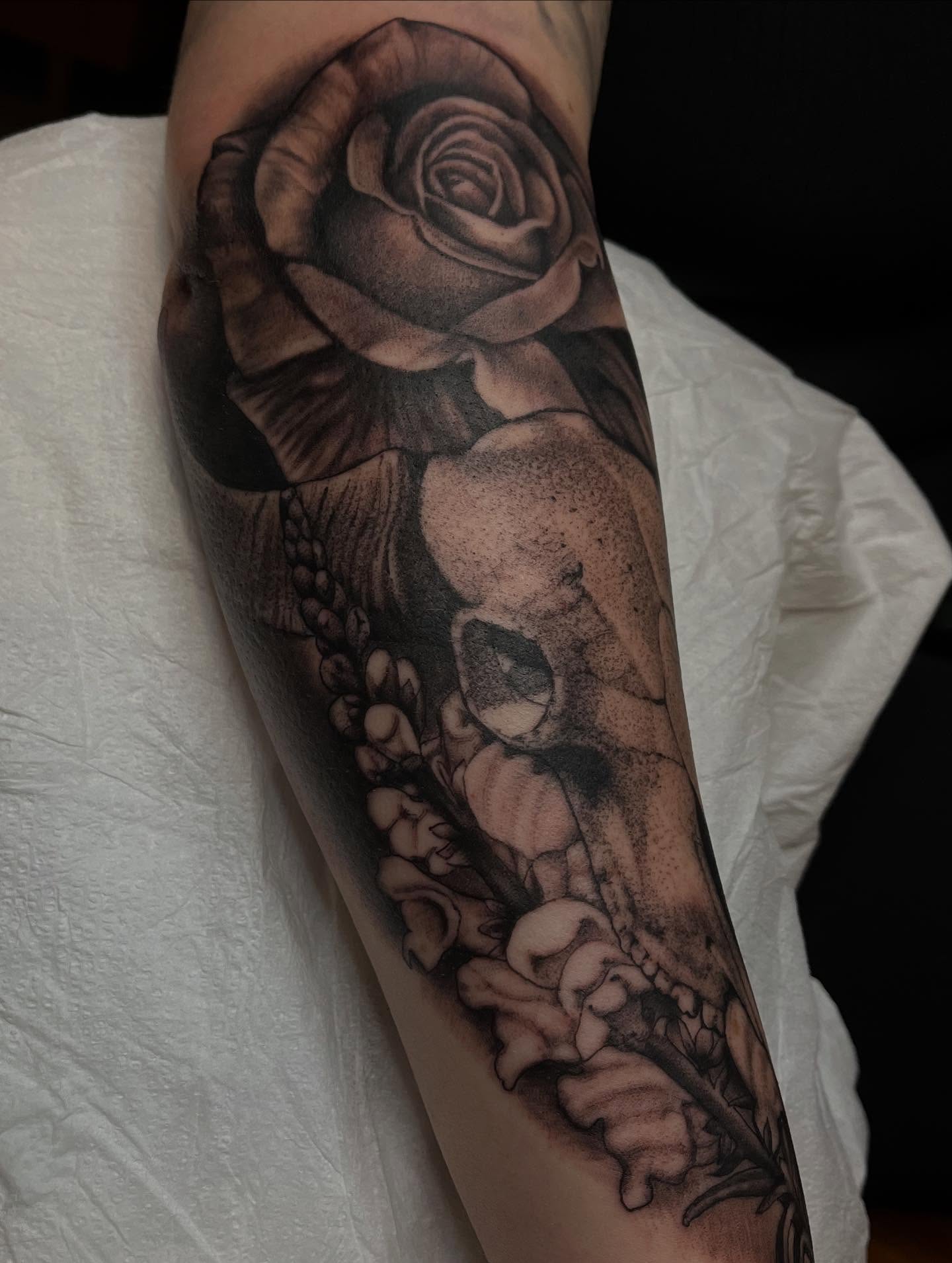Rose and skull realism tattoo on the forearm by Adam Habecker