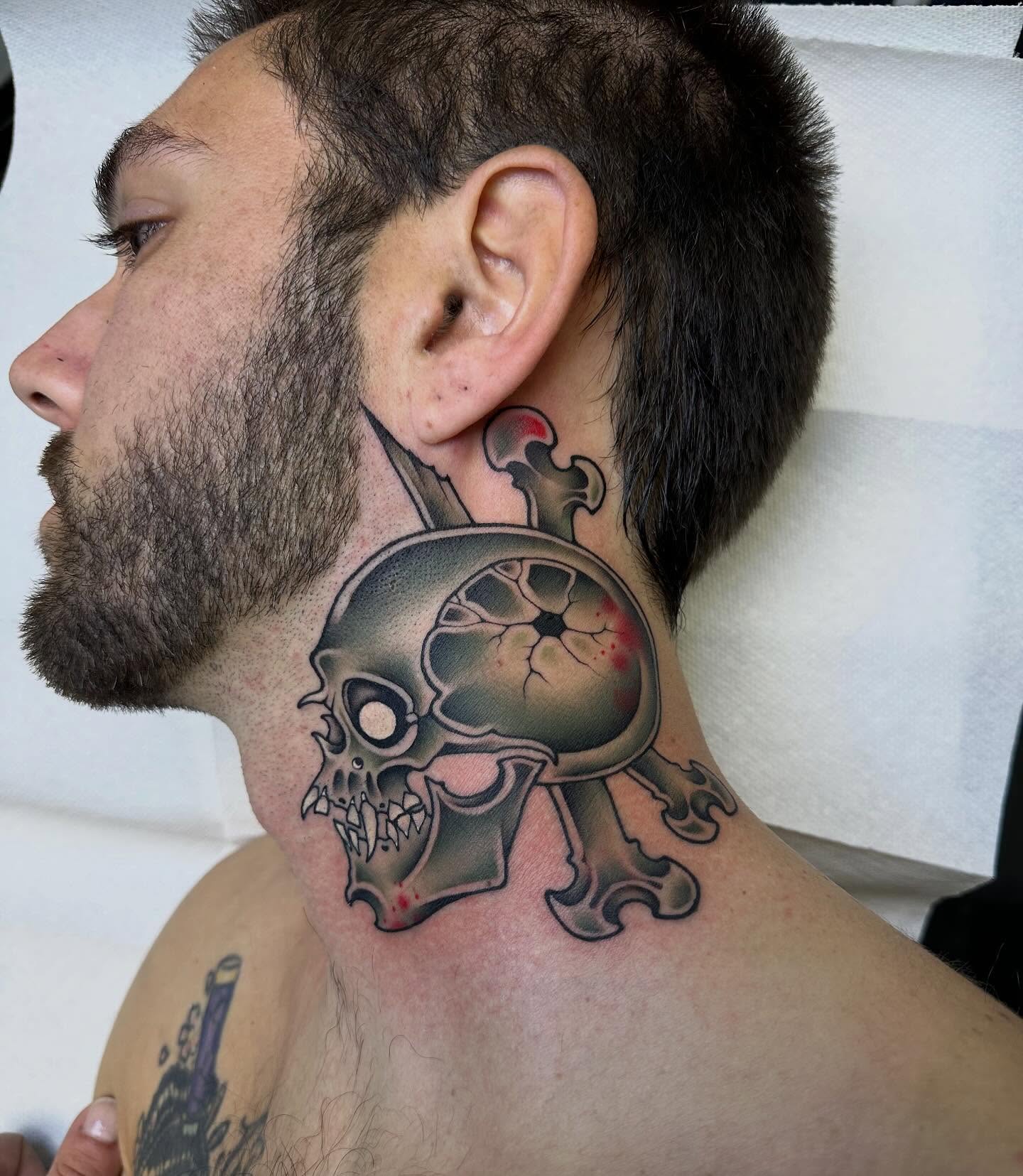 Skull and crossbones realism tattoo on the neck by Mark Boller
