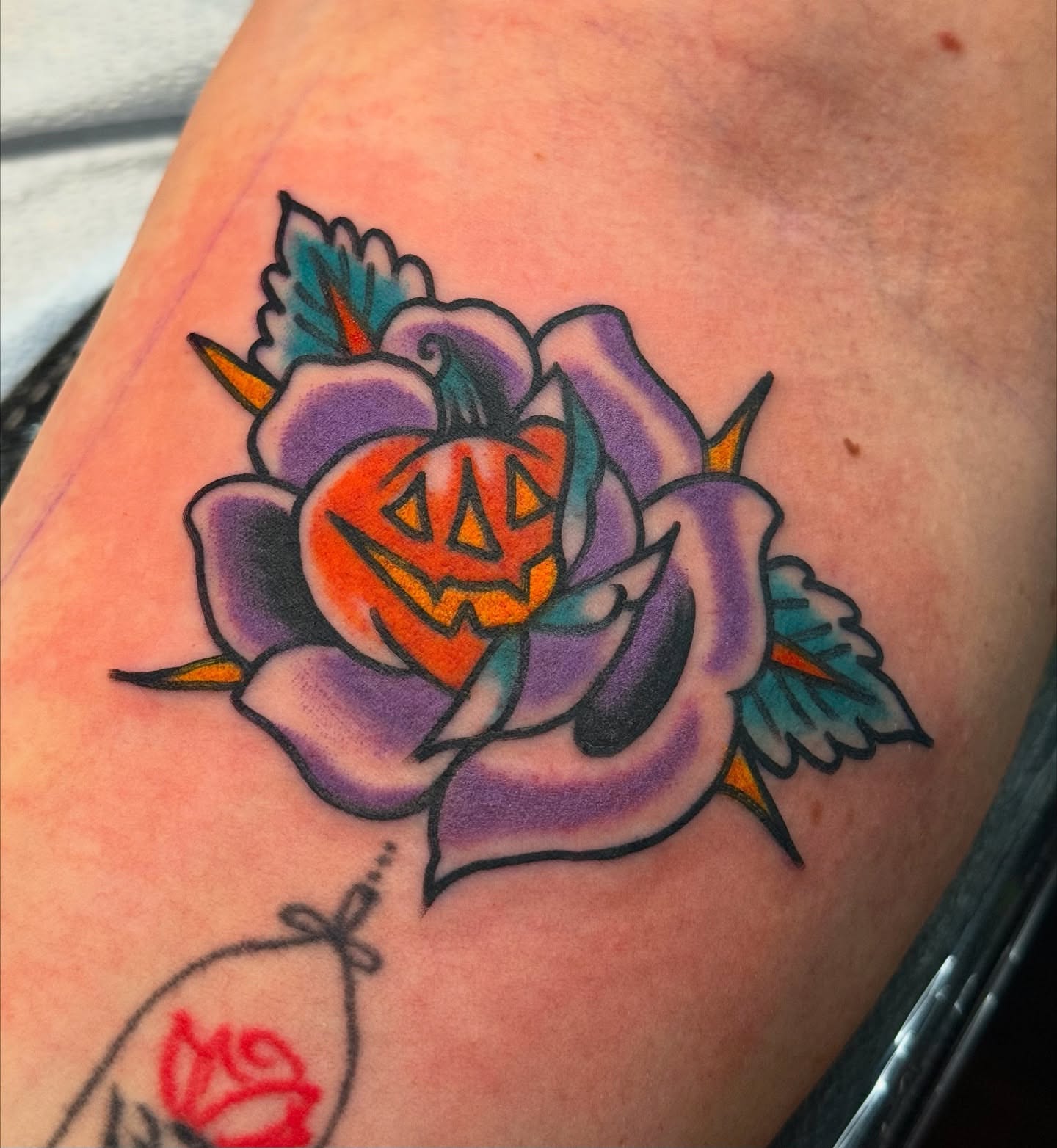 Pumpkin and rose American traditional tattoo on the forearm by sydtatz