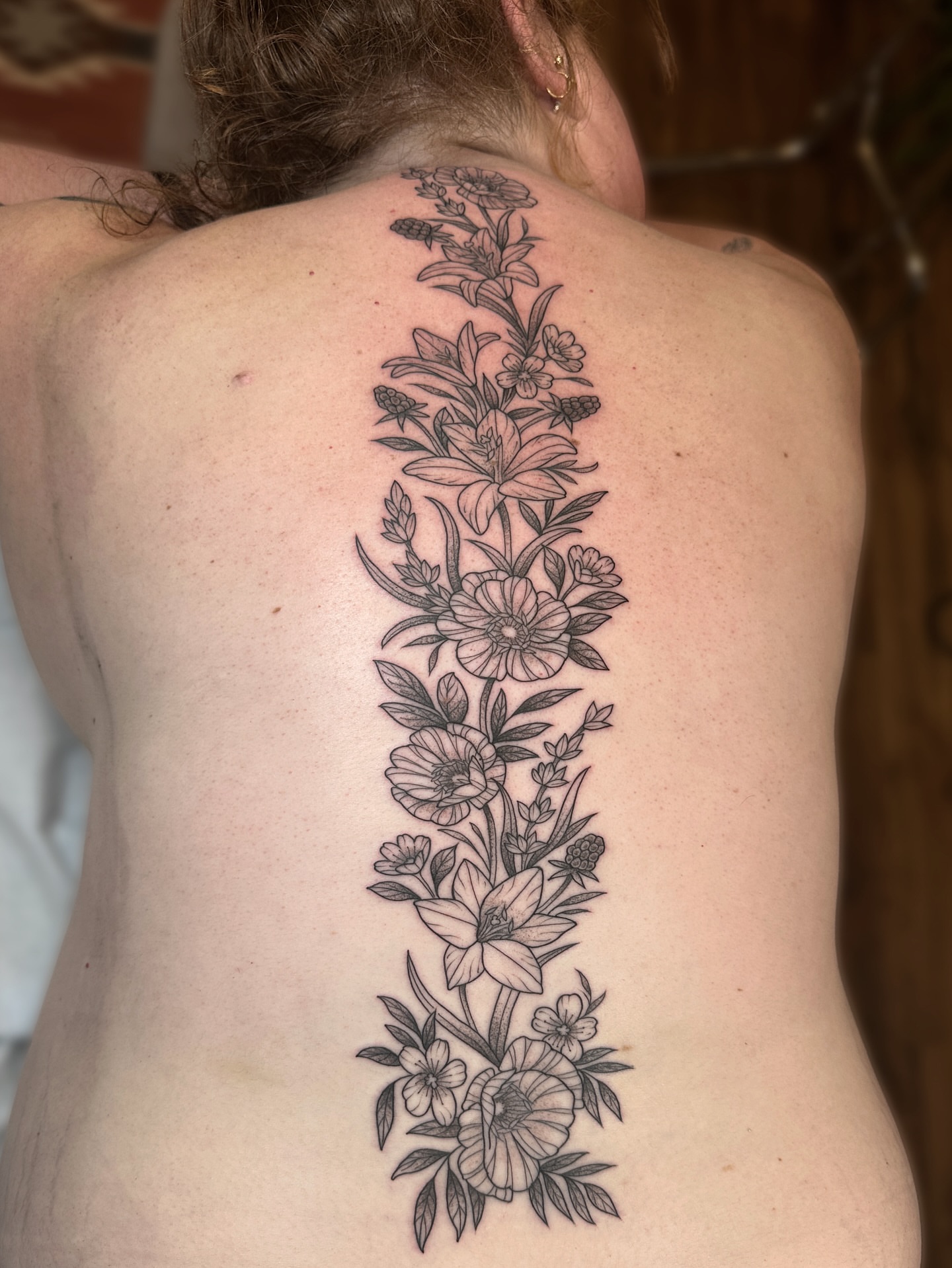 Floral arrangement black and grey tattoo on the back by Tattooing by Patty Valentine