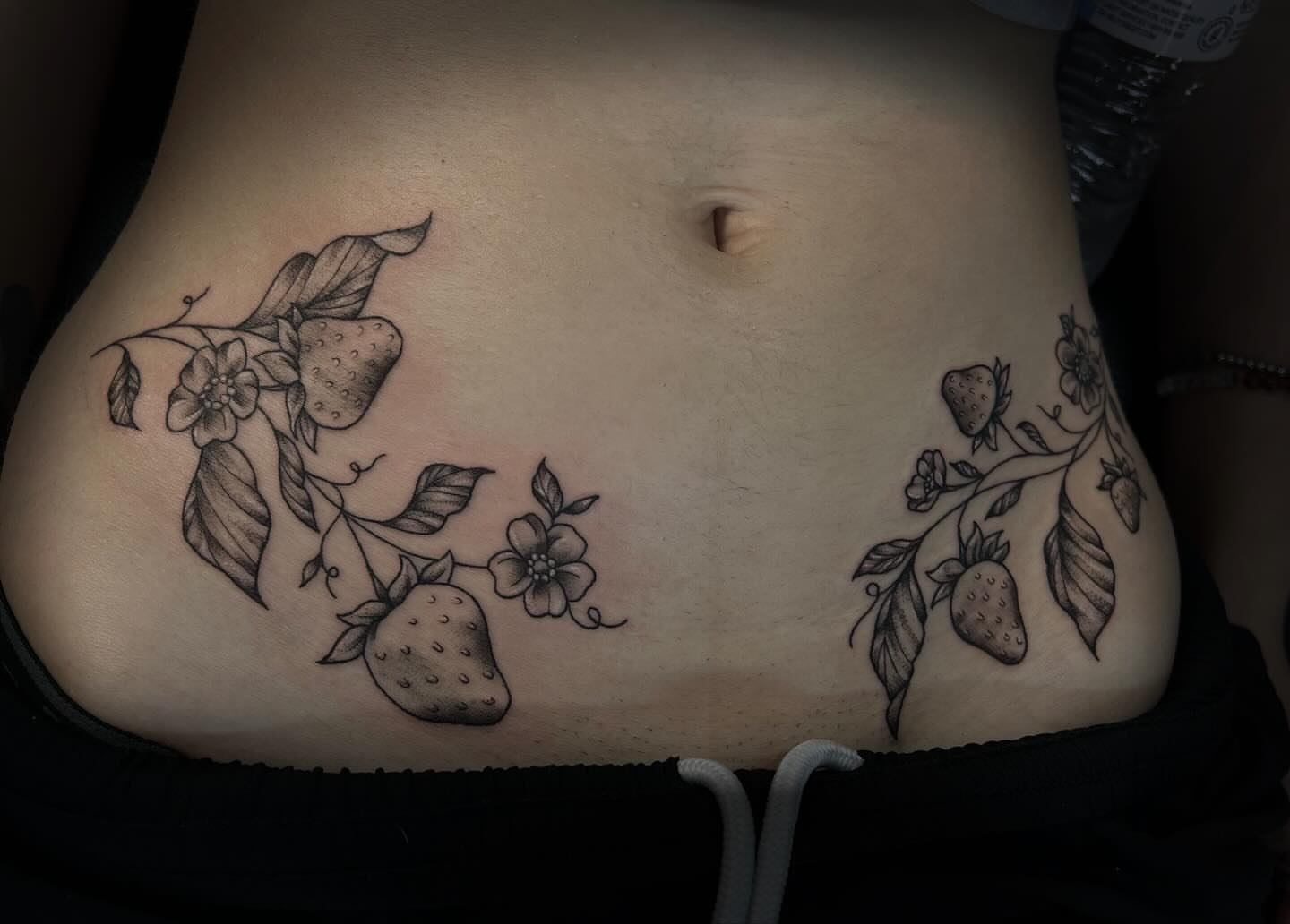 Strawberries and flowers black and grey tattoo on the torso by abby ☽ marie