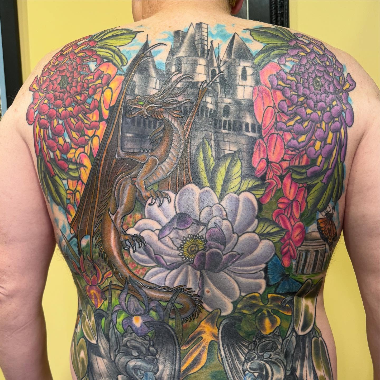 Castle, dragon, flowers dotwork tattoo on the back by Erin McDavis