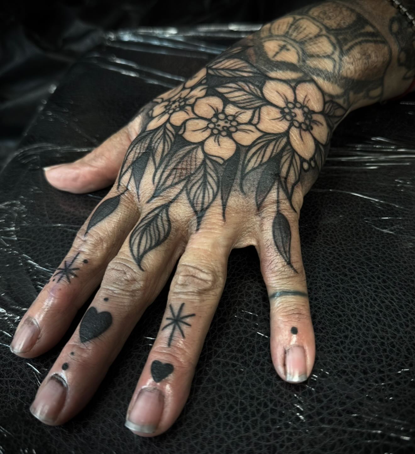 Floral hand tattoo black and grey tattoo on the hand by M A R I B e T H▪️k L A A R