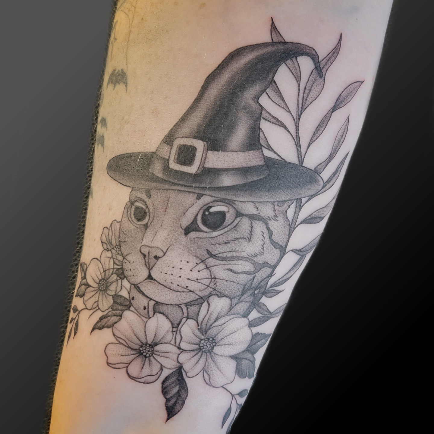 Cat wearing witch hat realism tattoo on the forearm by Arick Reese