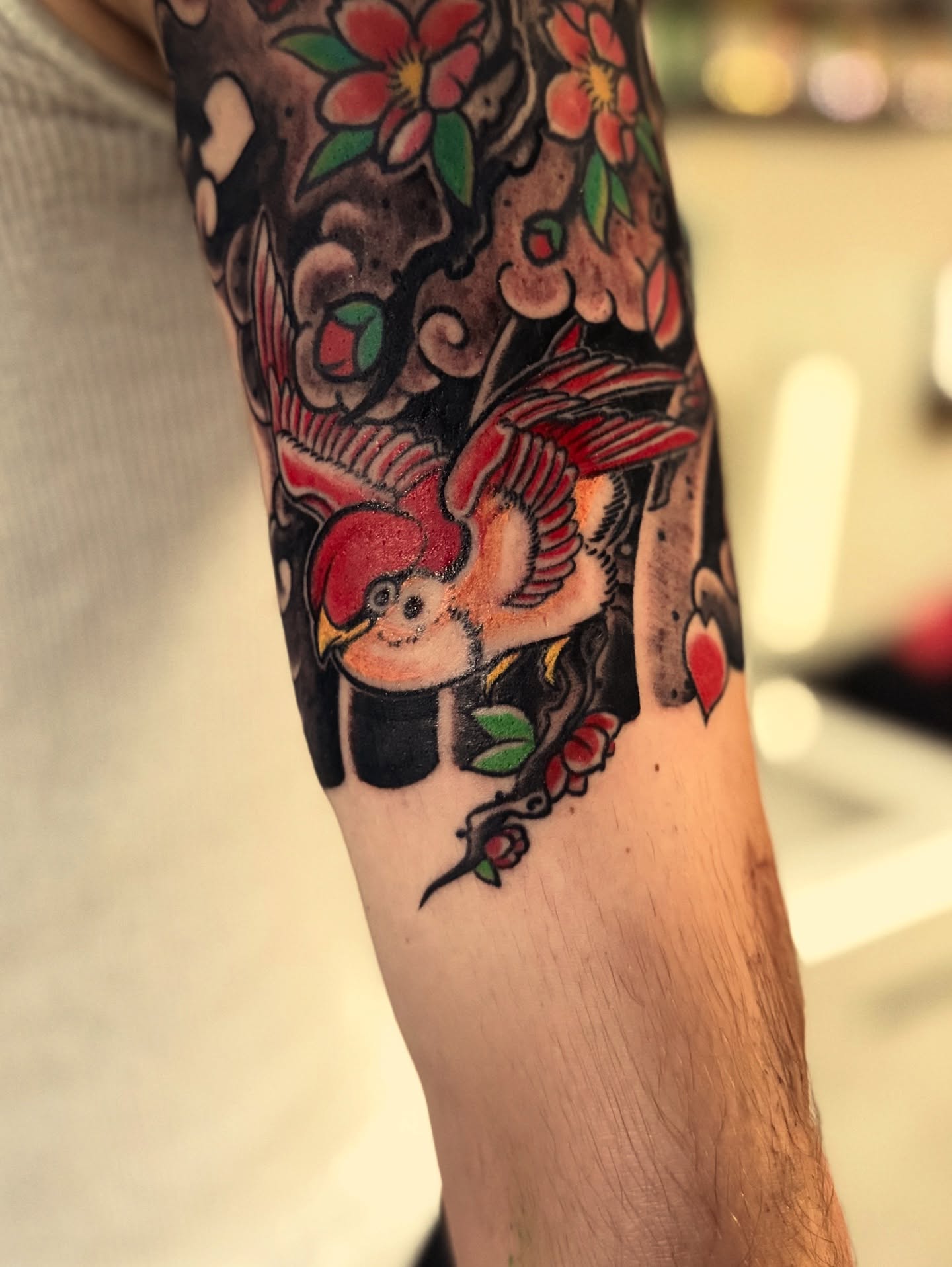 Bird and flowers American traditional tattoo on the forearm by Nick Weaver