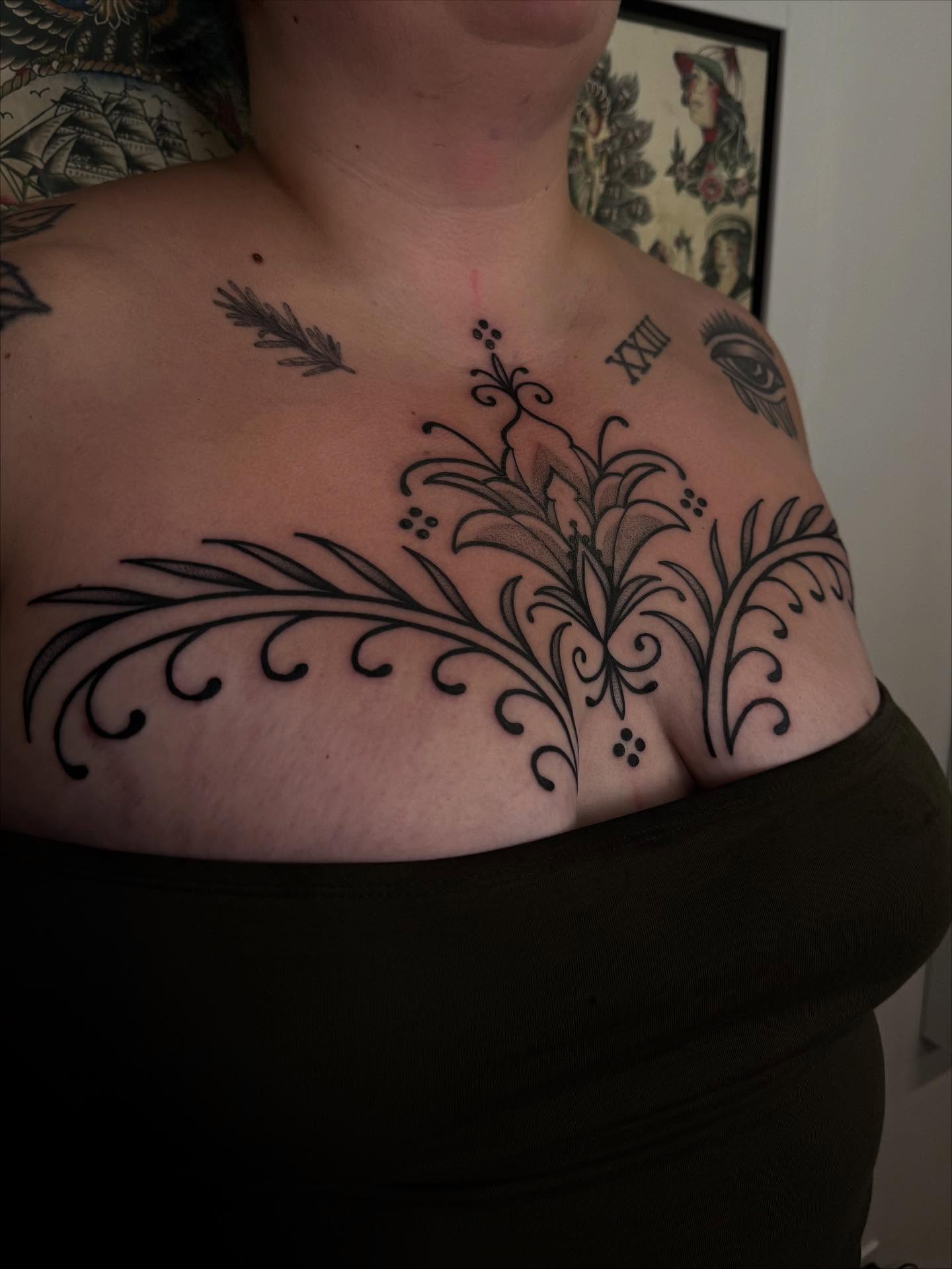 Floral design ornamental tattoo on the chest by Erin Shea