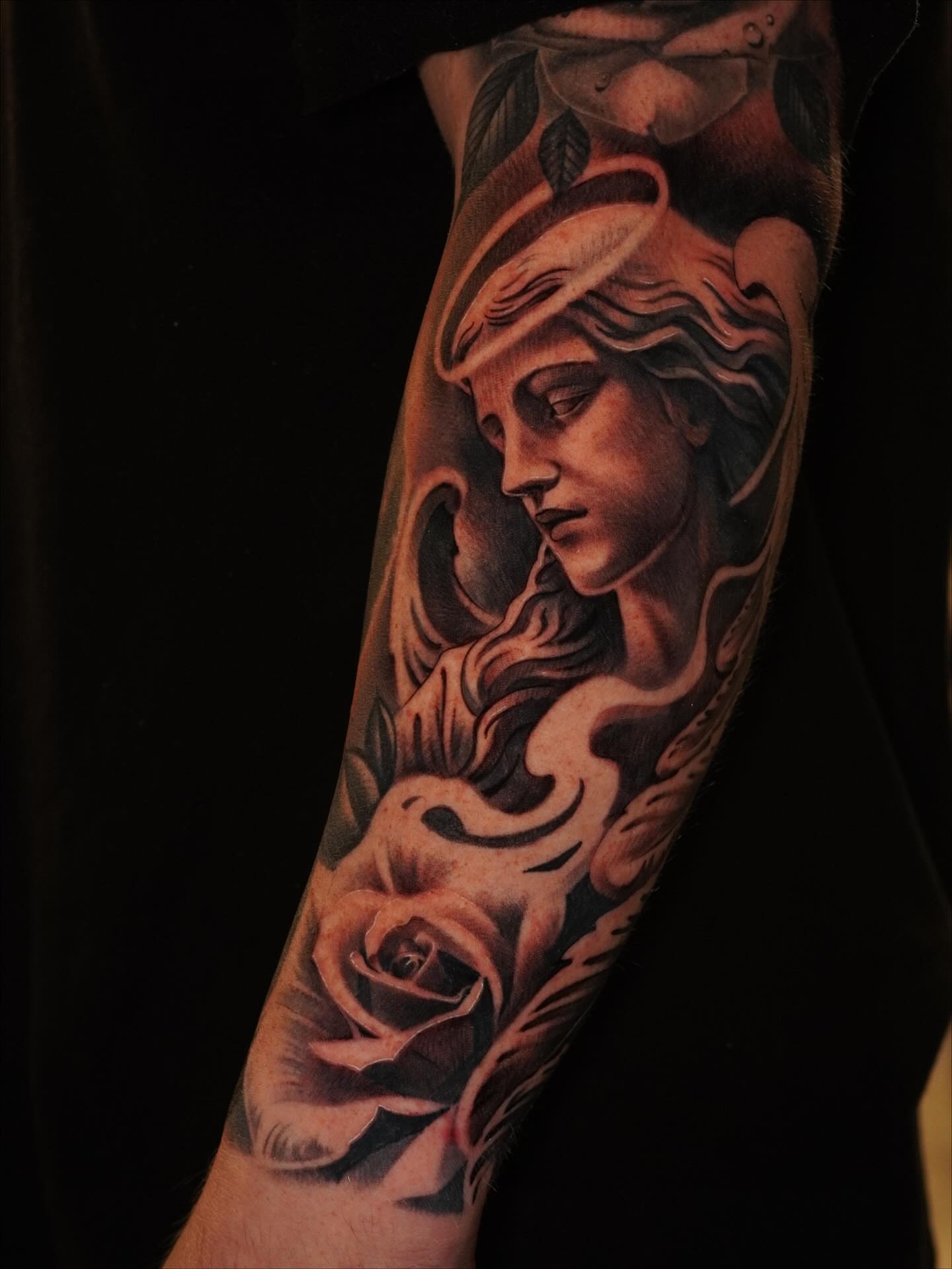 Woman with halo and rose realism tattoo on the forearm by Jesse Missman