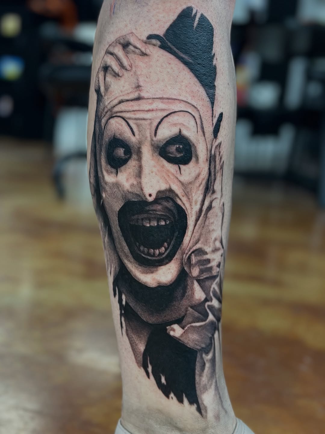 Art the Clown portrait realism tattoo on the forearm by Trent Hebert