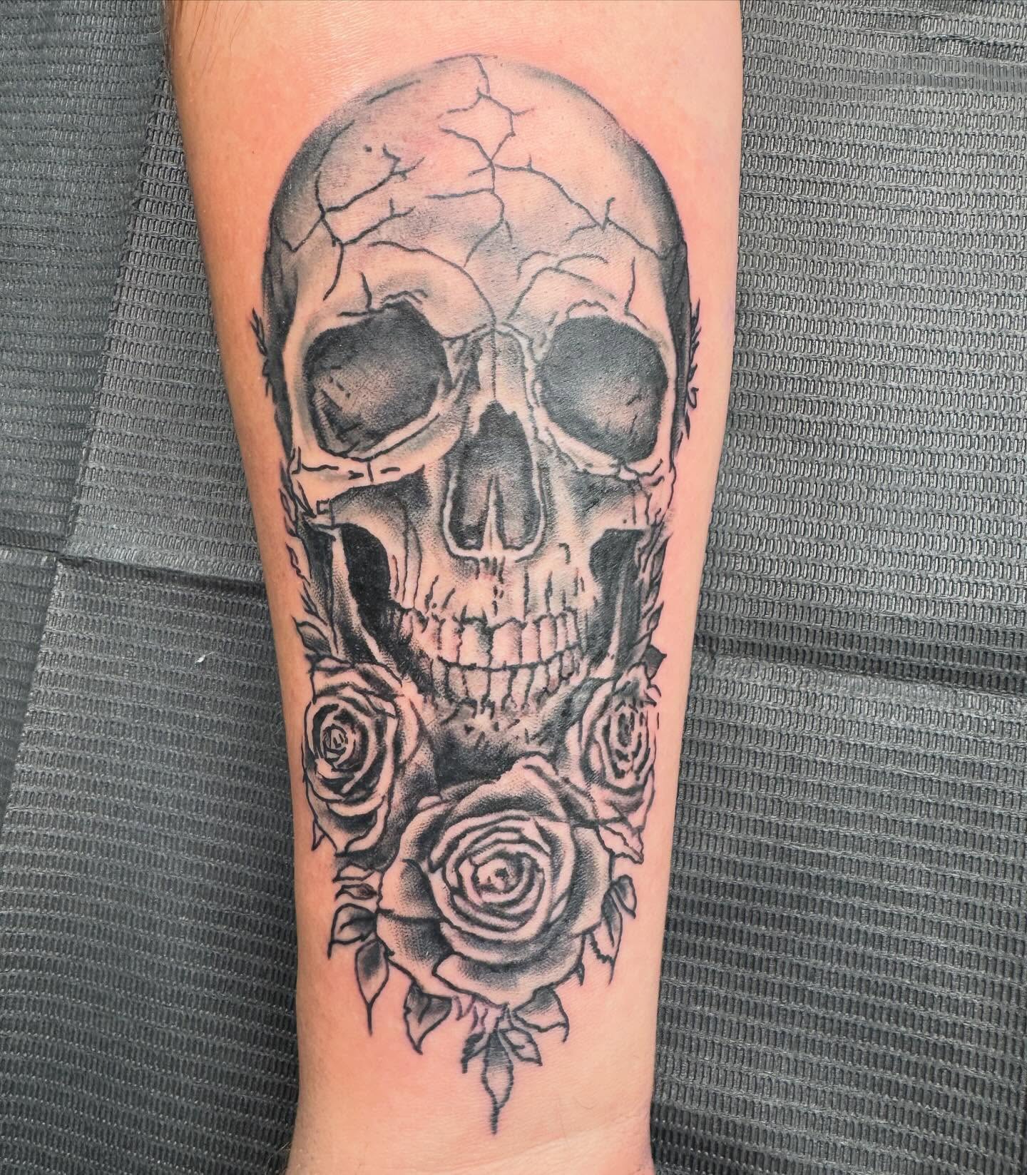 Skull with roses realism tattoo on the forearm by spikecitytattoo