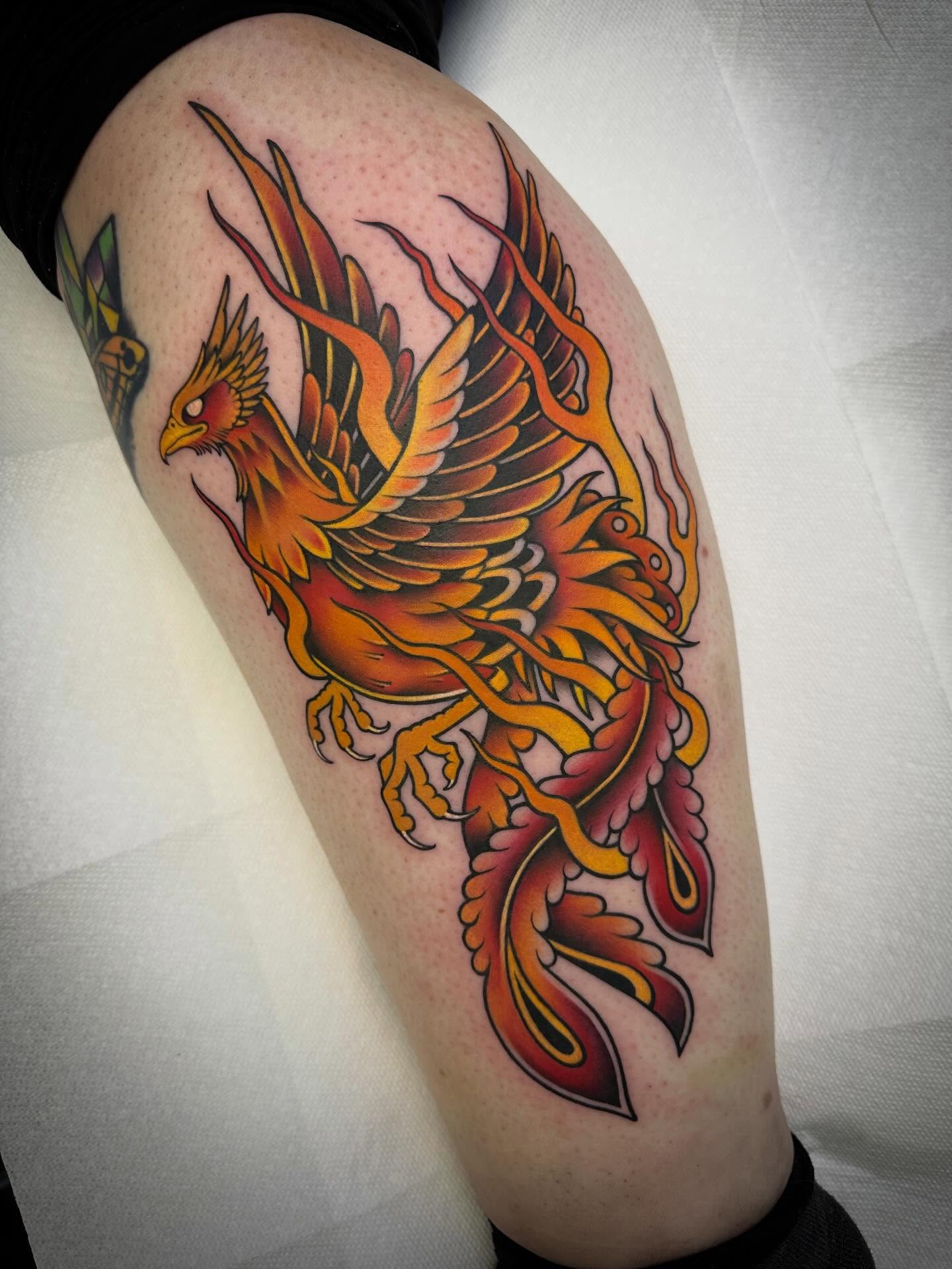 Phoenix American traditional tattoo on the thigh by Mark Boller