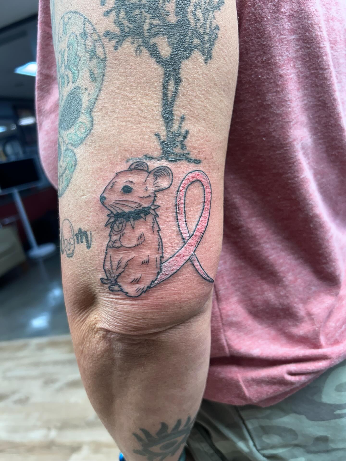 Mouse with pink ribbon realism tattoo on the forearm by Ricardo (RJ)