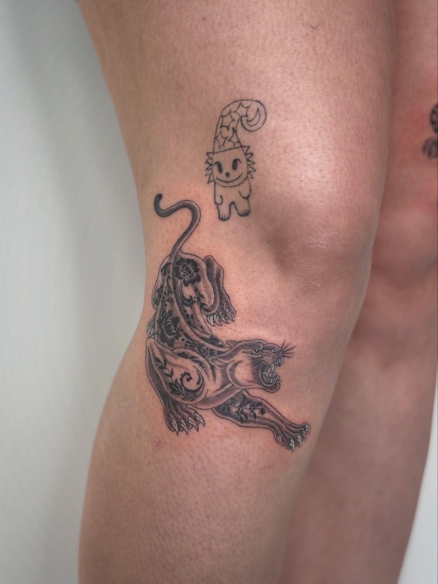 Cat and panther black and grey tattoo on the thigh by @tattotos