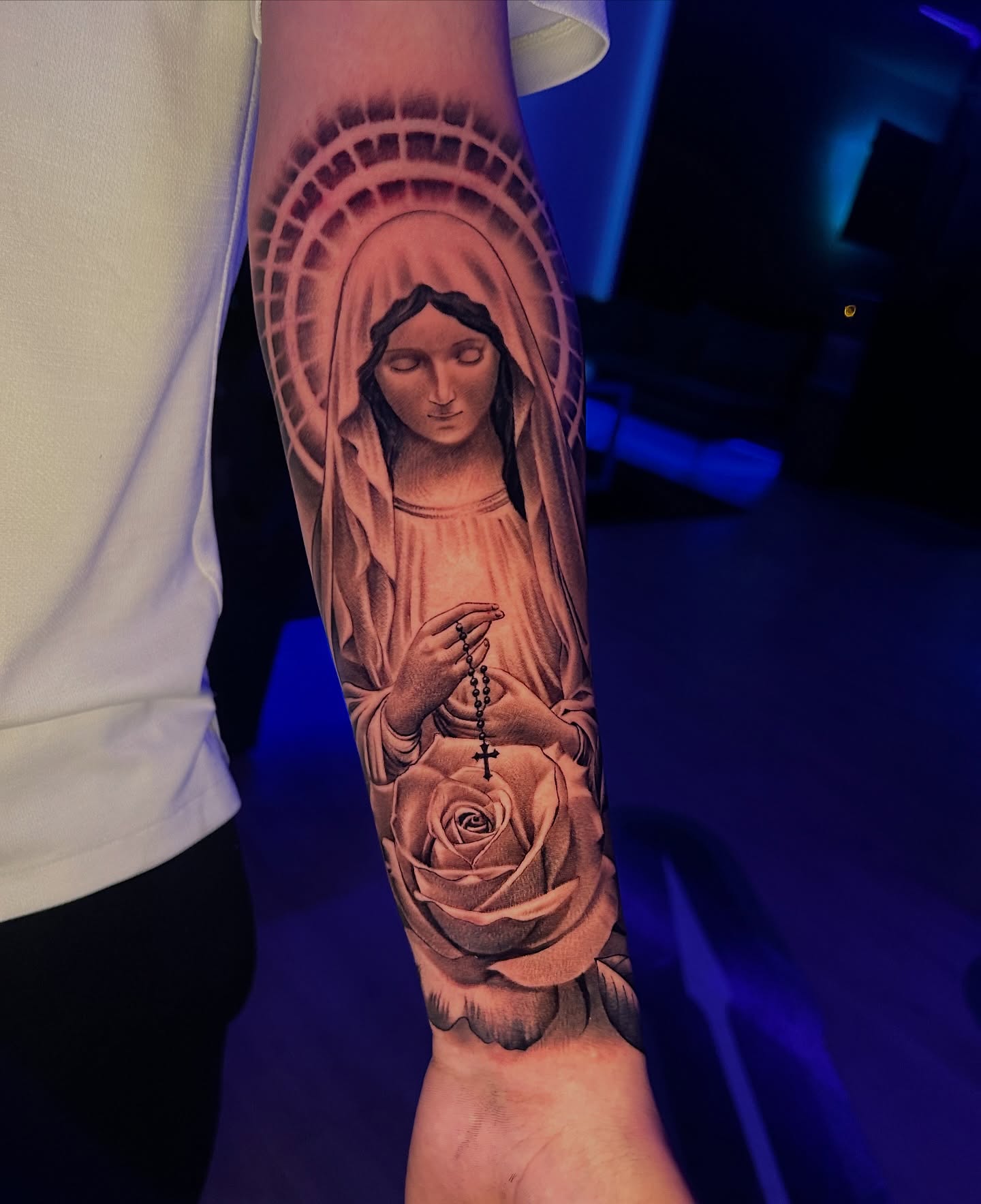 Religious figure with rose realism tattoo on the forearm by Luis VP