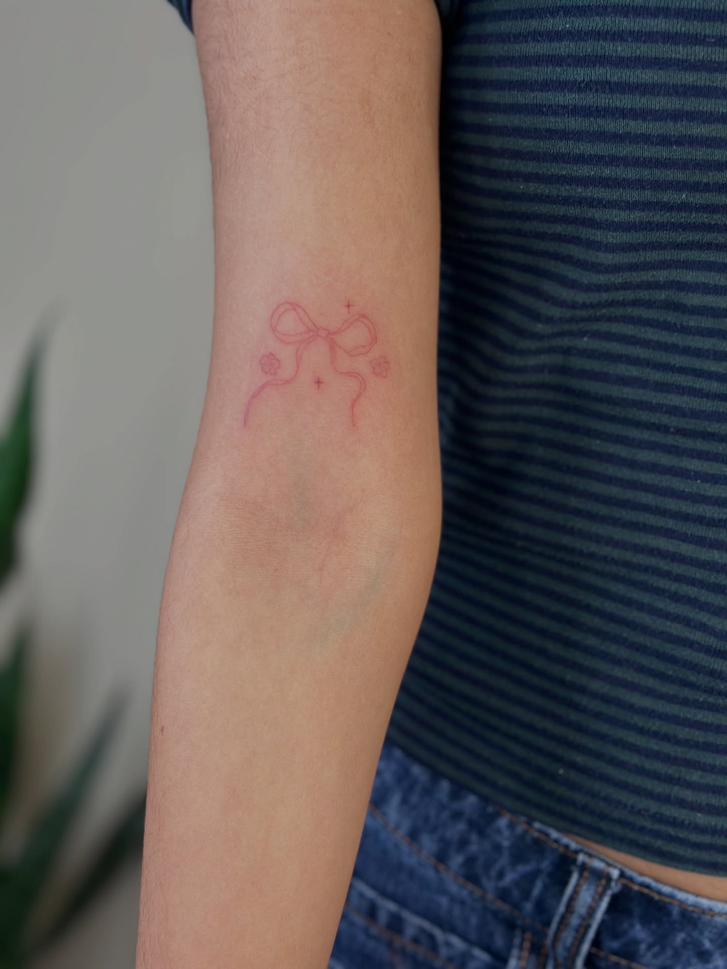 Bow fine line tattoo on the forearm by Cherry🥀