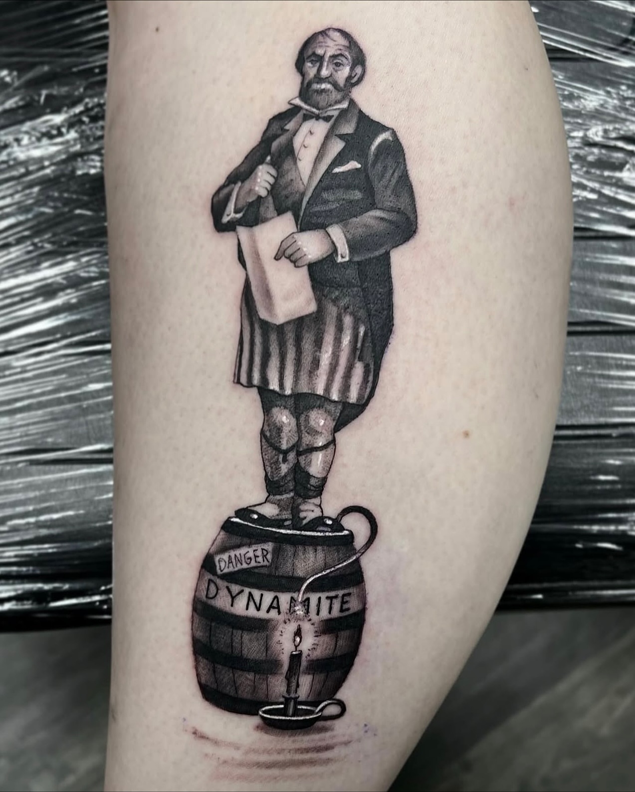 Man standing on dynamite black and grey tattoo on the forearm by Madison Ast Tattoo