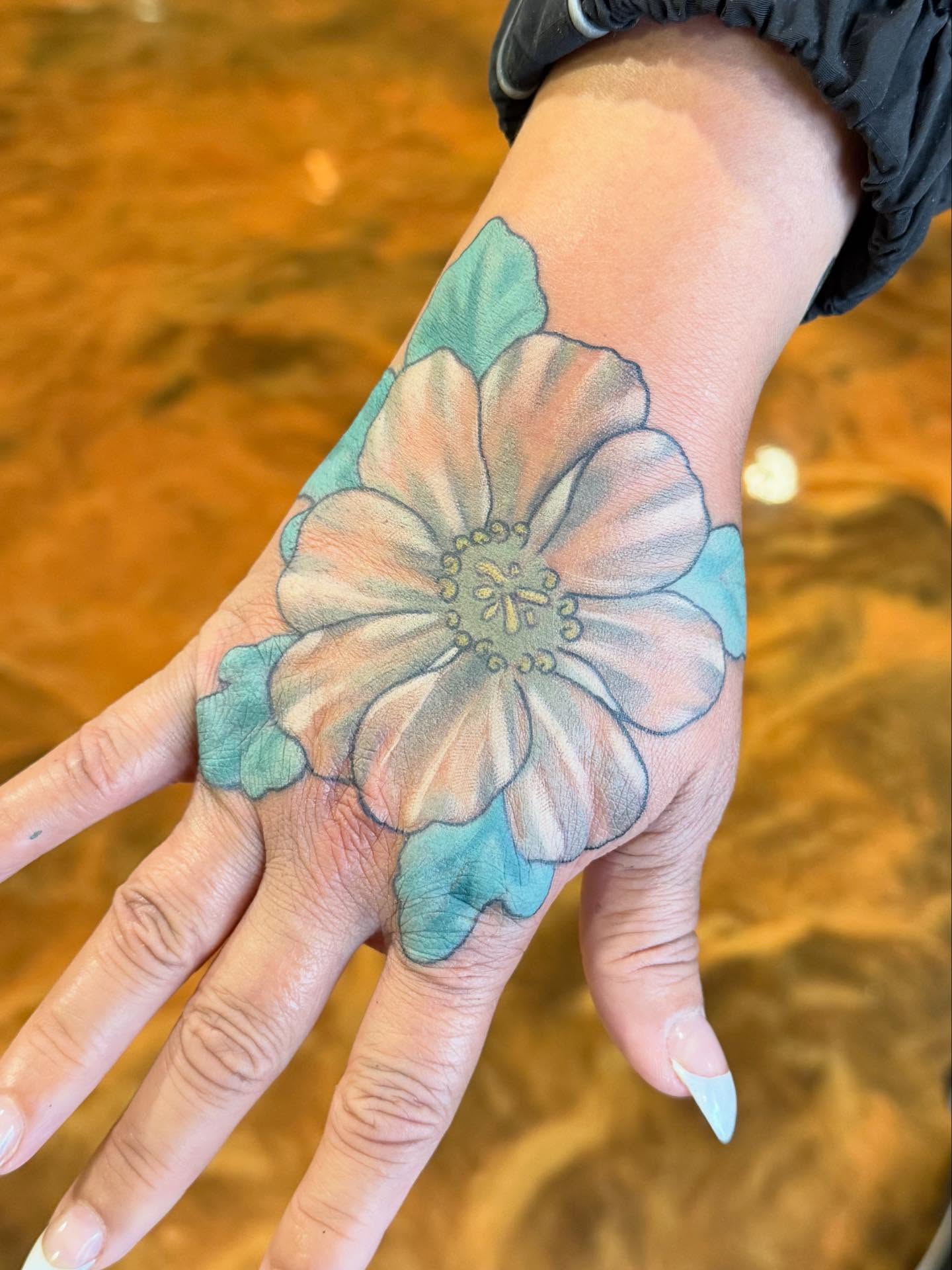 Flower watercolor tattoo on the hand by Erin McDavis