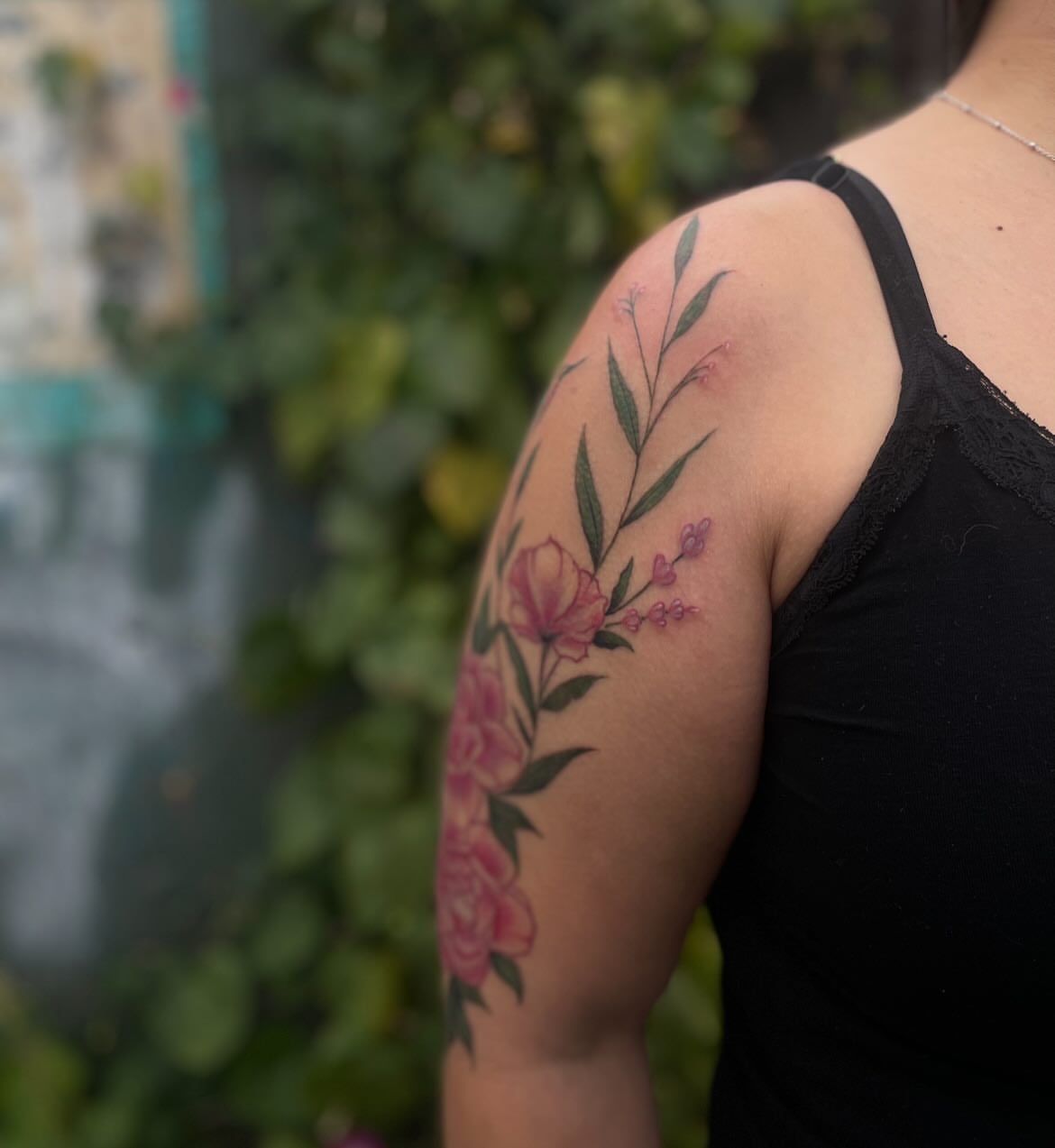 Floral arrangement new school tattoo on the upper arm by Trinity