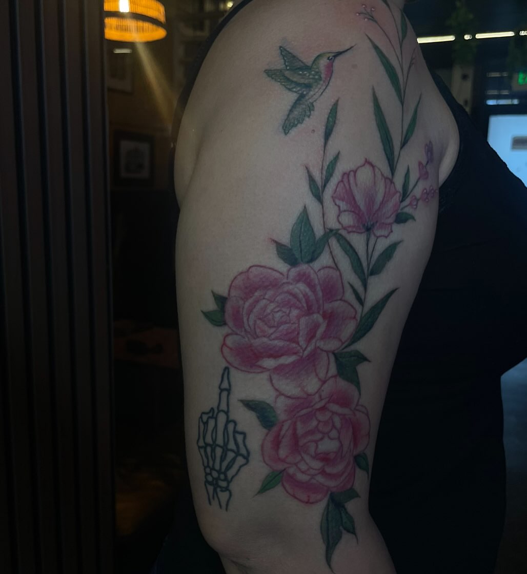 Peonies and hummingbird realism tattoo on the upper arm by Trinity