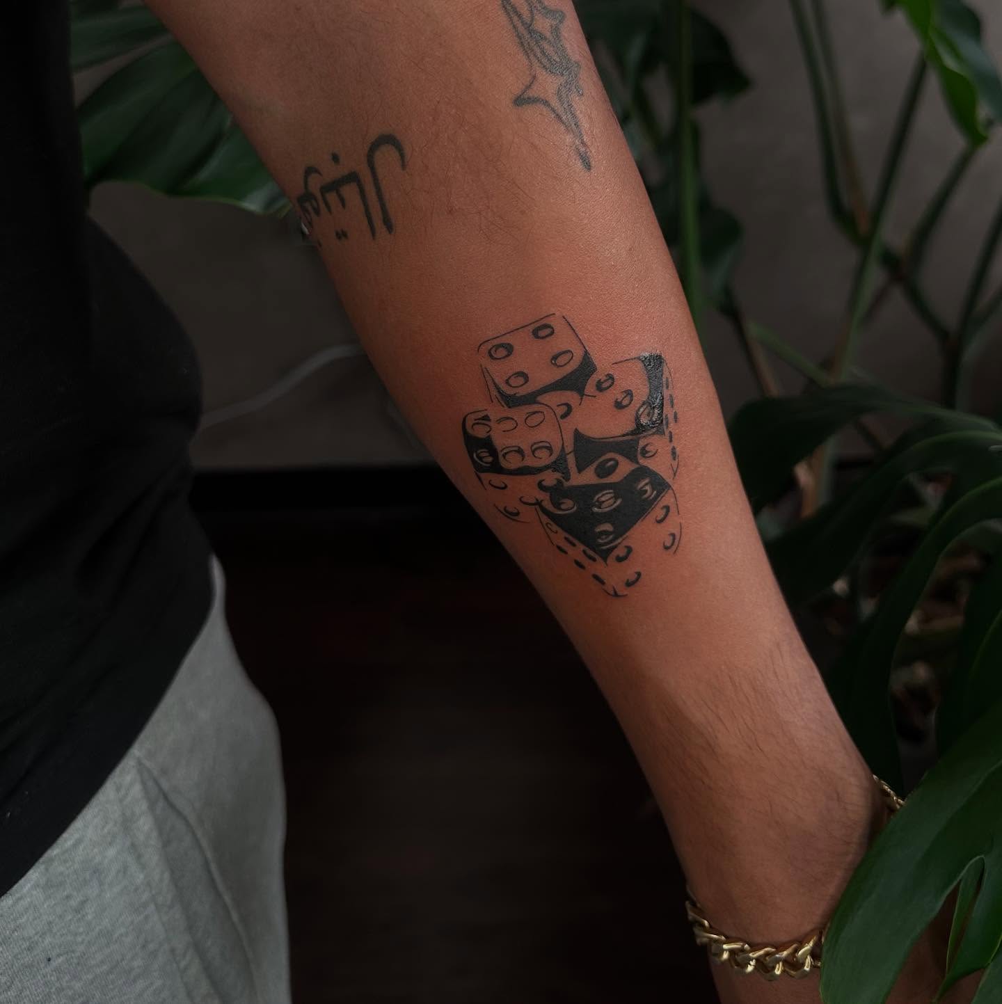 Dice black and grey tattoo on the forearm by Liv