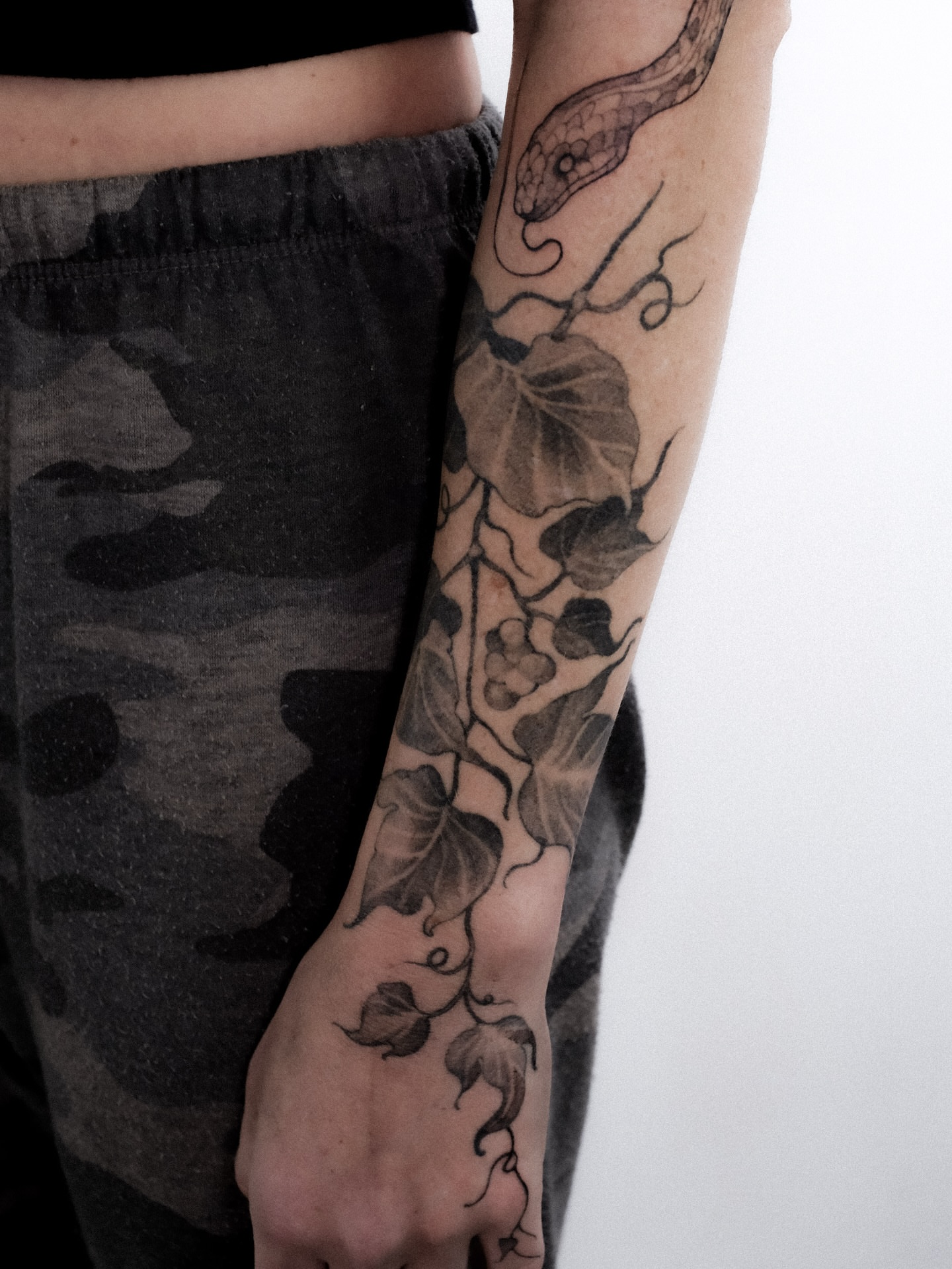 Vine and snake realism tattoo on the forearm by Alena Zozulenko