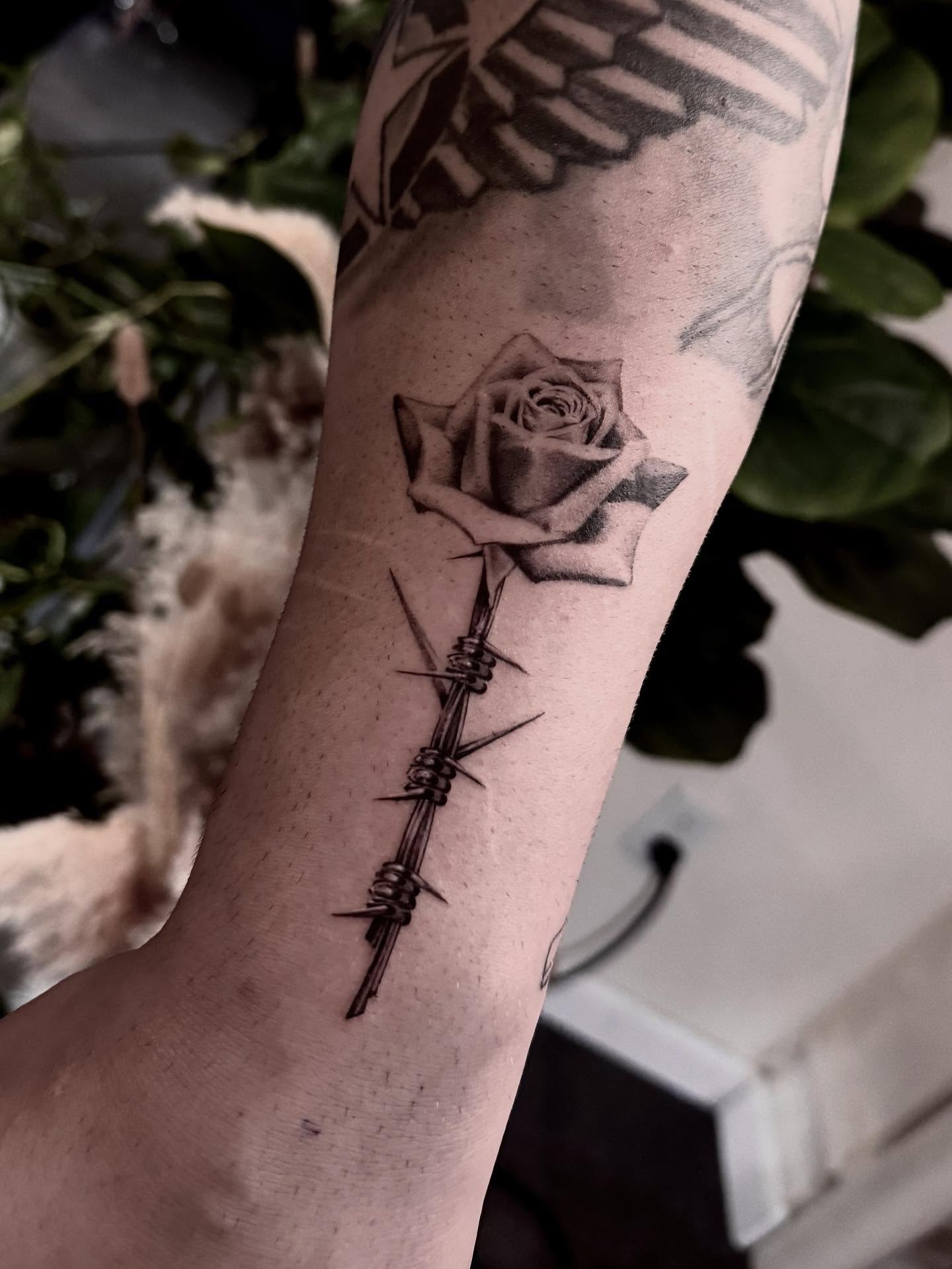 Rose with barbed wire realism tattoo on the forearm by Oori