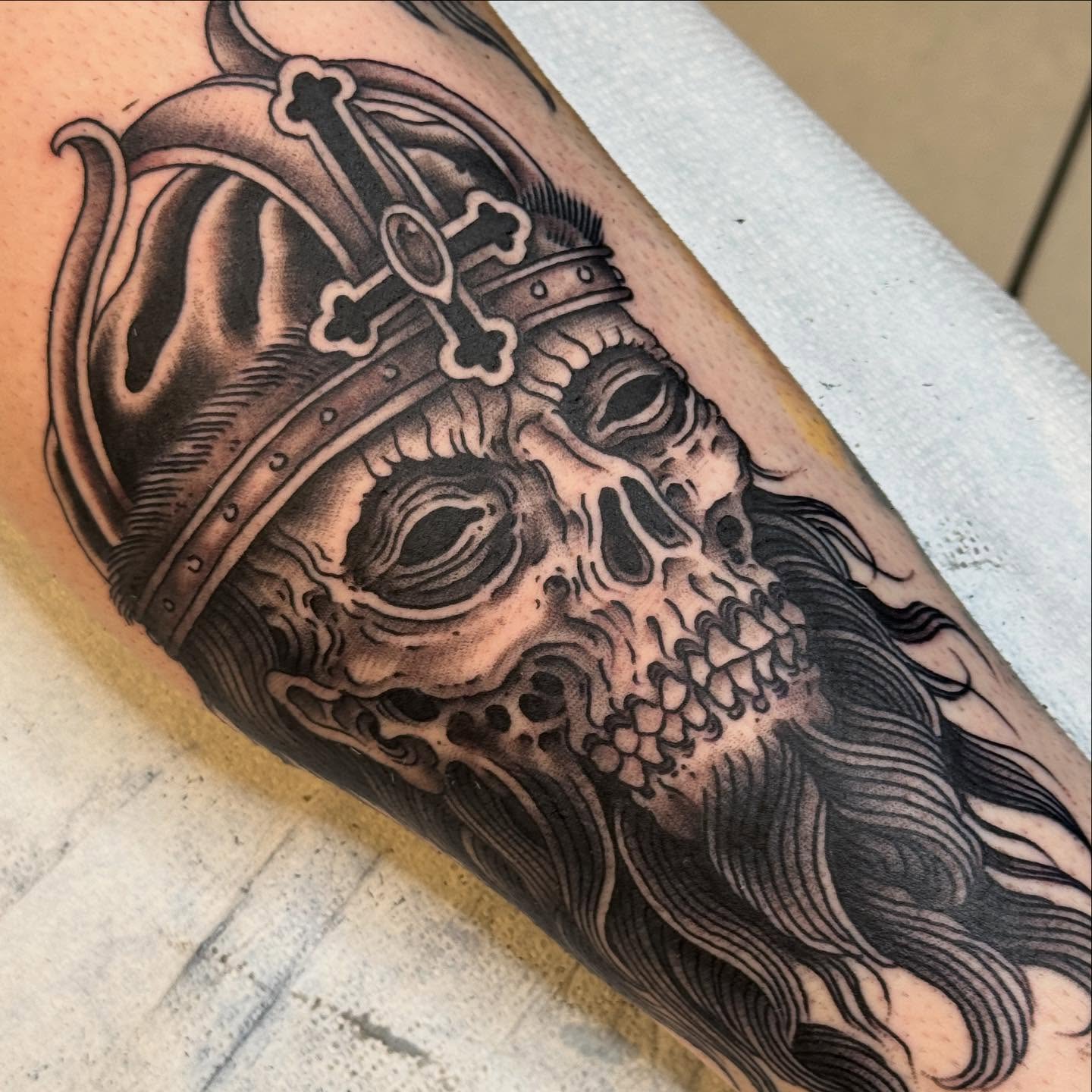 Skull wearing crown realism tattoo on the forearm by Derek Noble, San Francisco, California